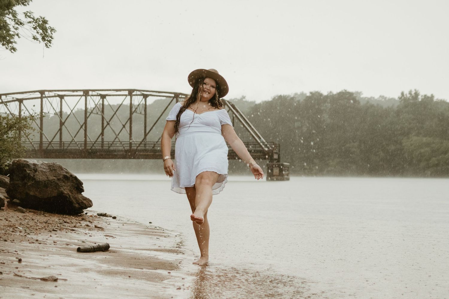 Someone walks gracefully along misty lake beach wearing flowing white dress near Broken Bridges on Lake Hartwell.