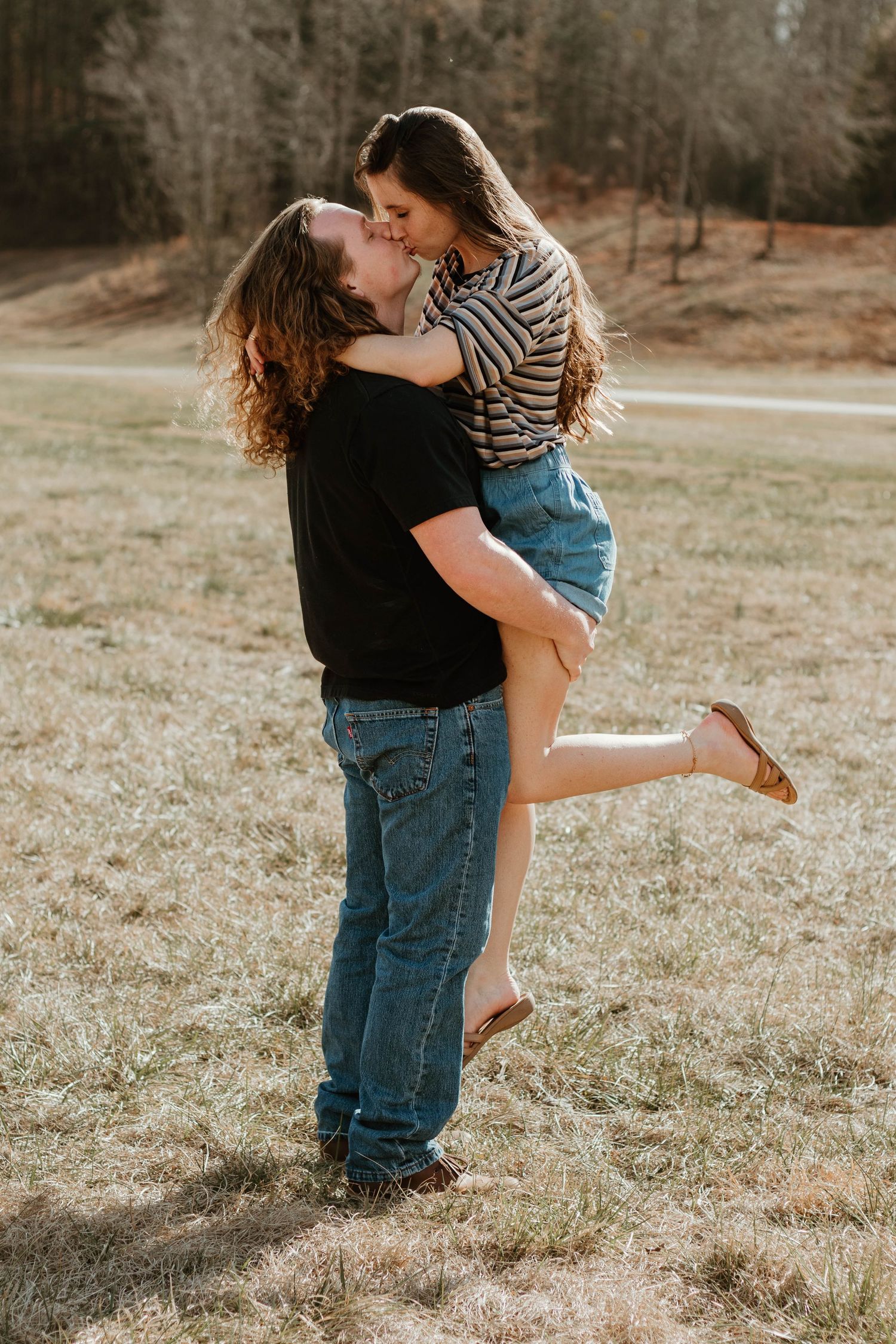Romantic couple embracing in open field with lifted pose at Geary Farm in Toccoa.
