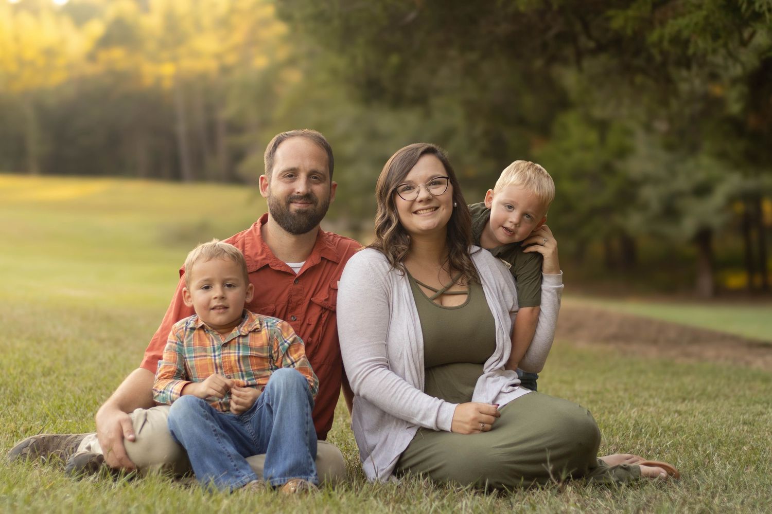 Family portrait session on grass in warm evening sunlight at Geary Farm in Toccoa, Georgia.