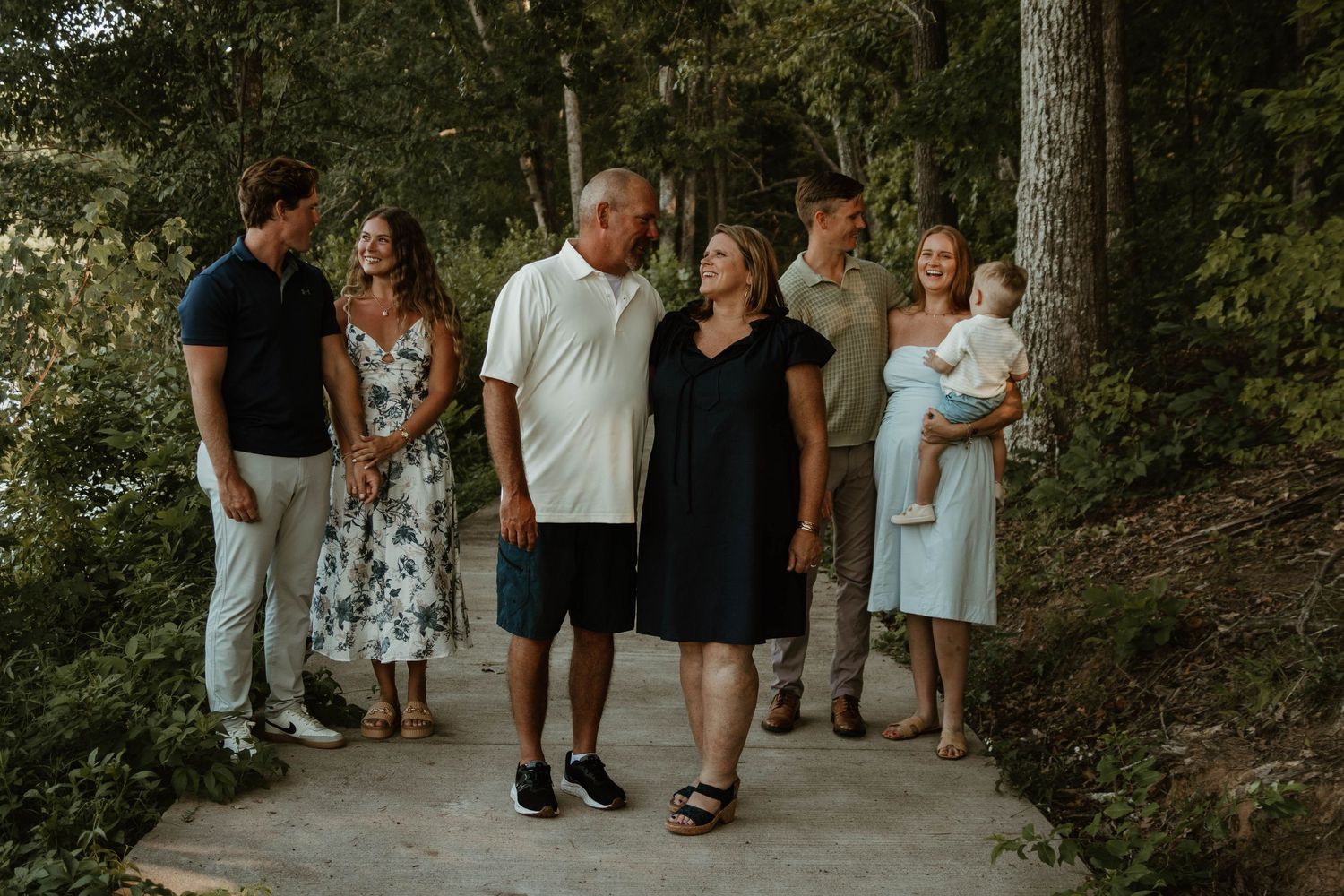 People walking along a tree-lined path during a summer outdoor gathering at Lake Toccoa in northeast Georgia.