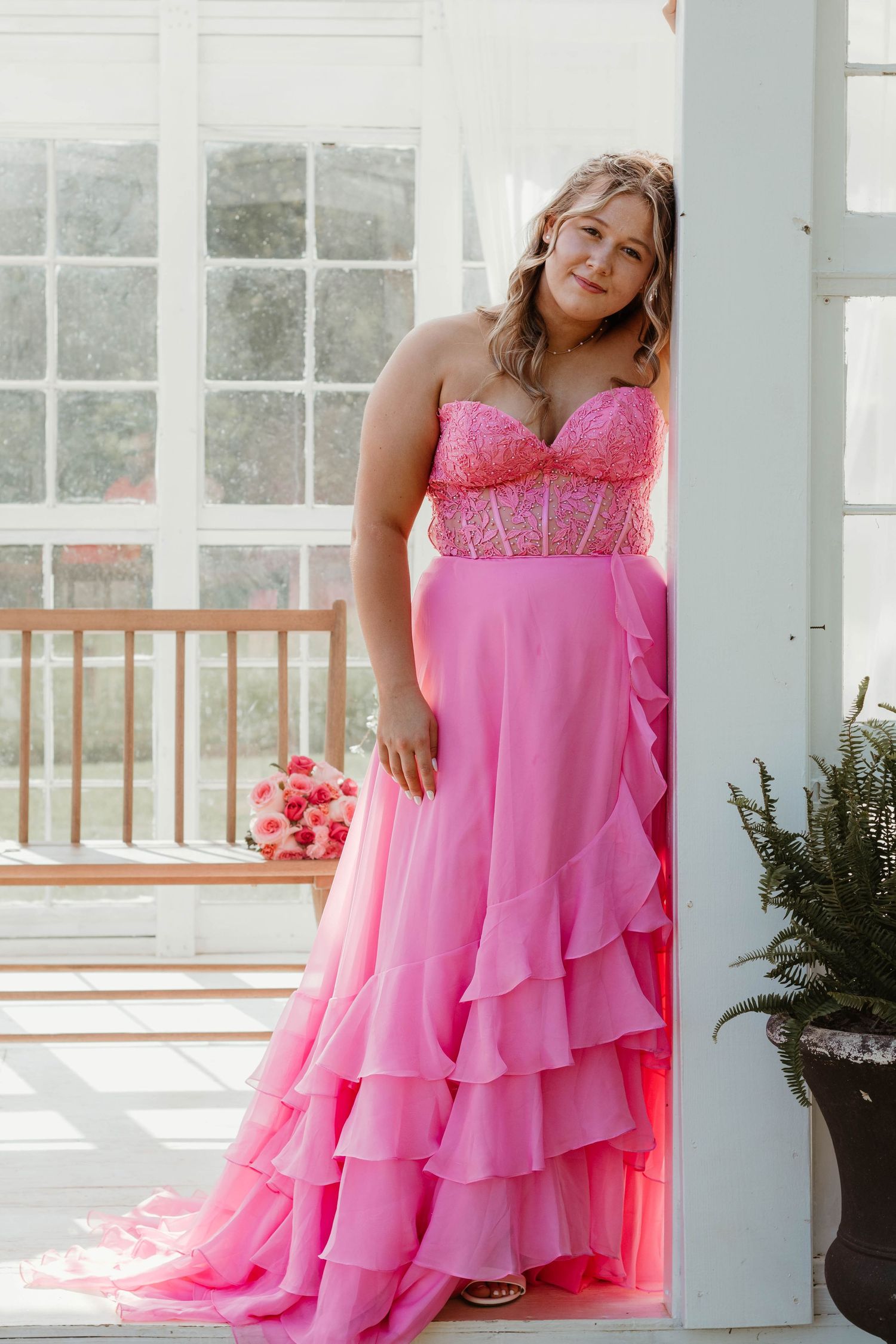 Pink layered formal dress with sweetheart neckline photographed against white pillars in natural light at a local farm in Clarkesville, GA.