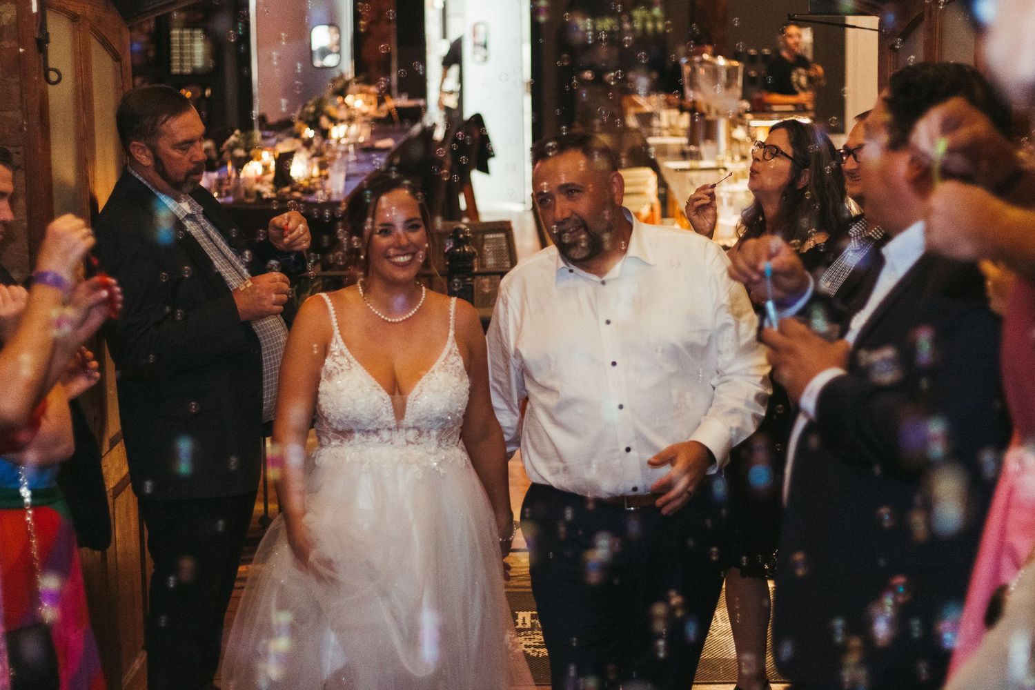 Wedding guests celebrate with sparklers as the bride in a white dress walks through during bubble exit in Greenville, SC.