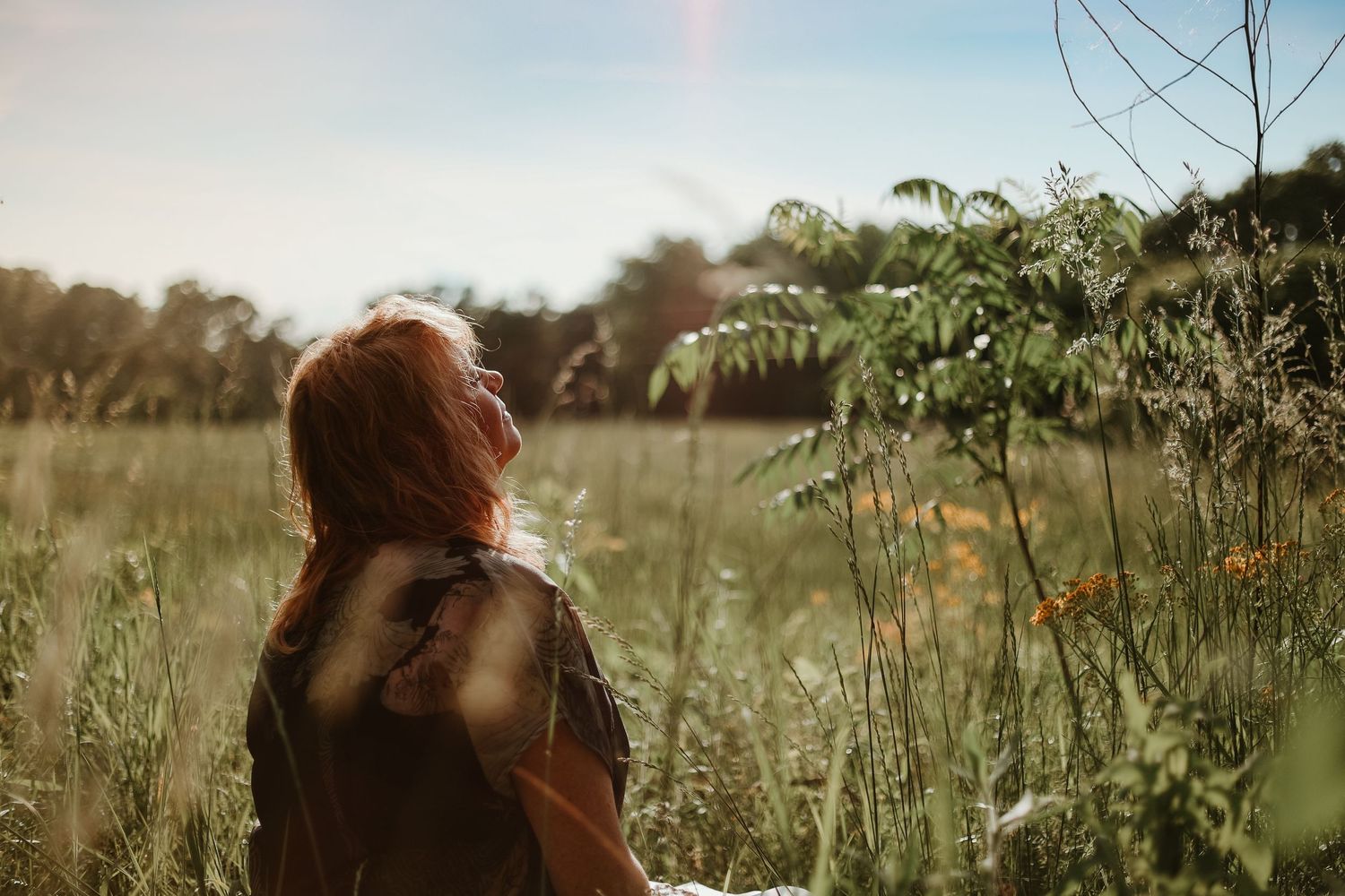 Artistic portrait in sun-drenched field with wildflowers and natural bokeh effects near Athens, GA.