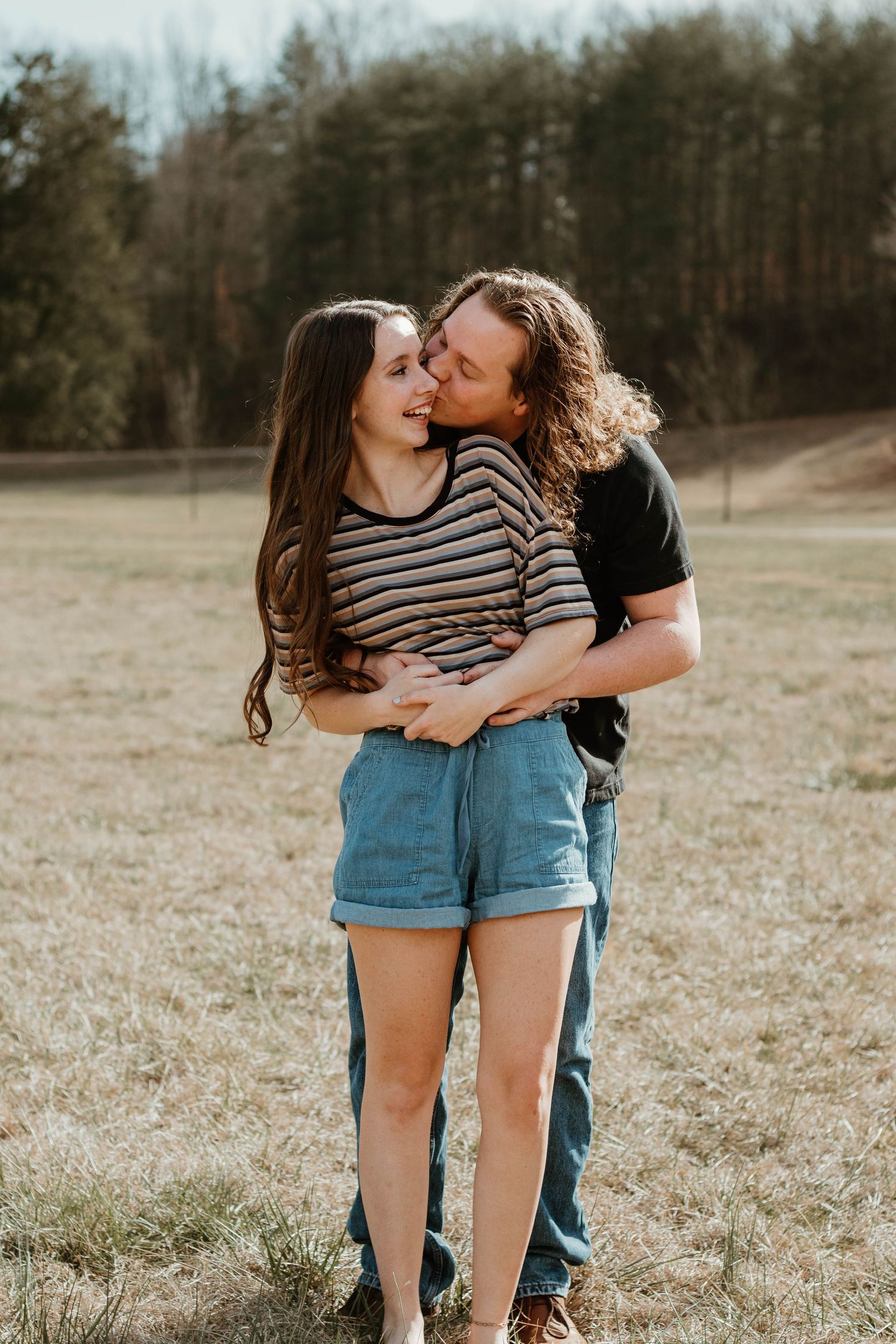 Couple sharing tender moment in outdoor field during autumn in north Georgia.