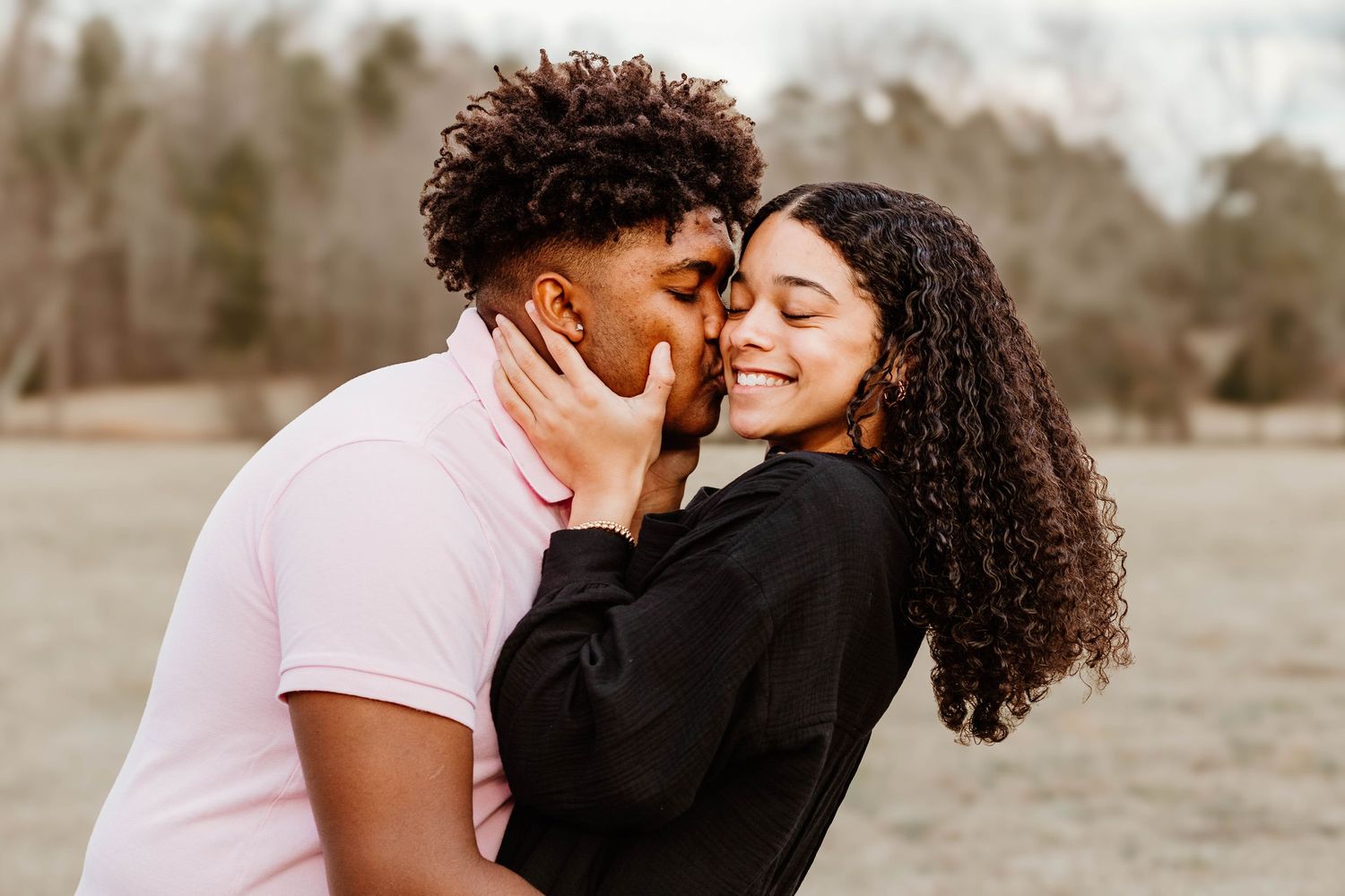 A romantic moment captured between a couple in contrasting outfits sharing an intimate gesture at Geary Farm in Northeast Georgia..