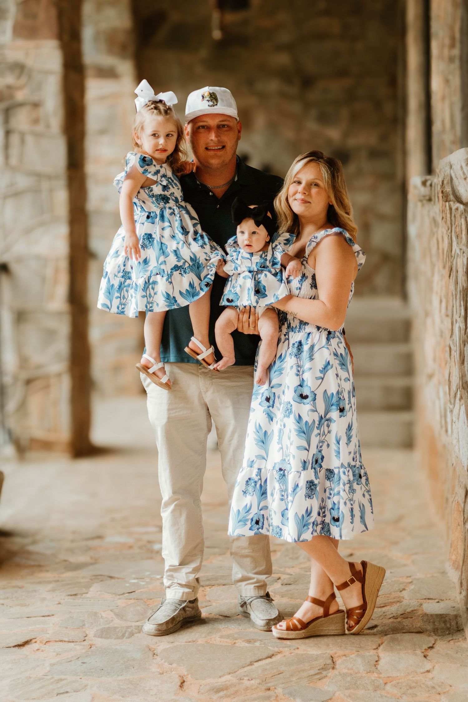 People in coordinating blue and white outfits pose together in a stone archway at Cornelia Community House in Northeast Georgia.