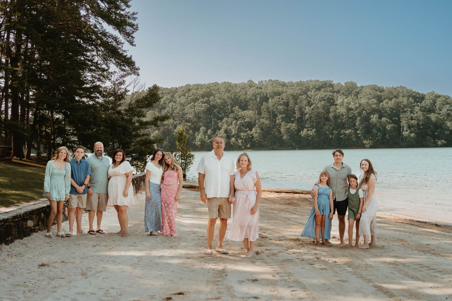 Extended family group photo at a lakeside beach during sunrise at Tugaloo State Park on Lake Hartwell.
