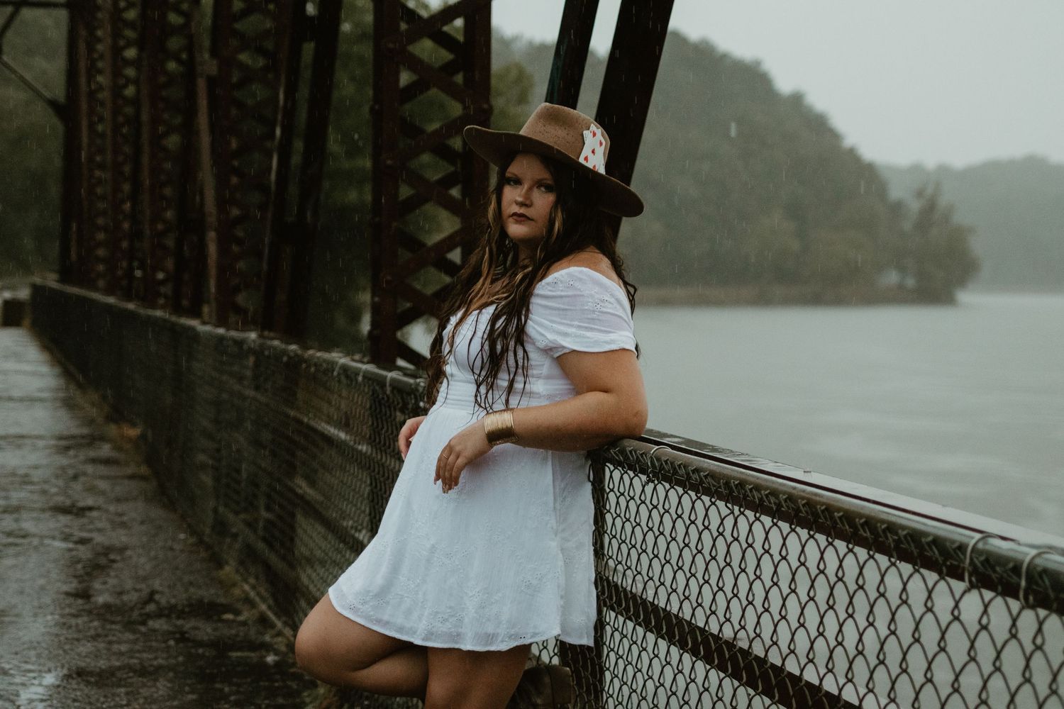 Someone in a white dress walks along Broken Bridges with a Lake Hartwell visible in the background during golden hour.