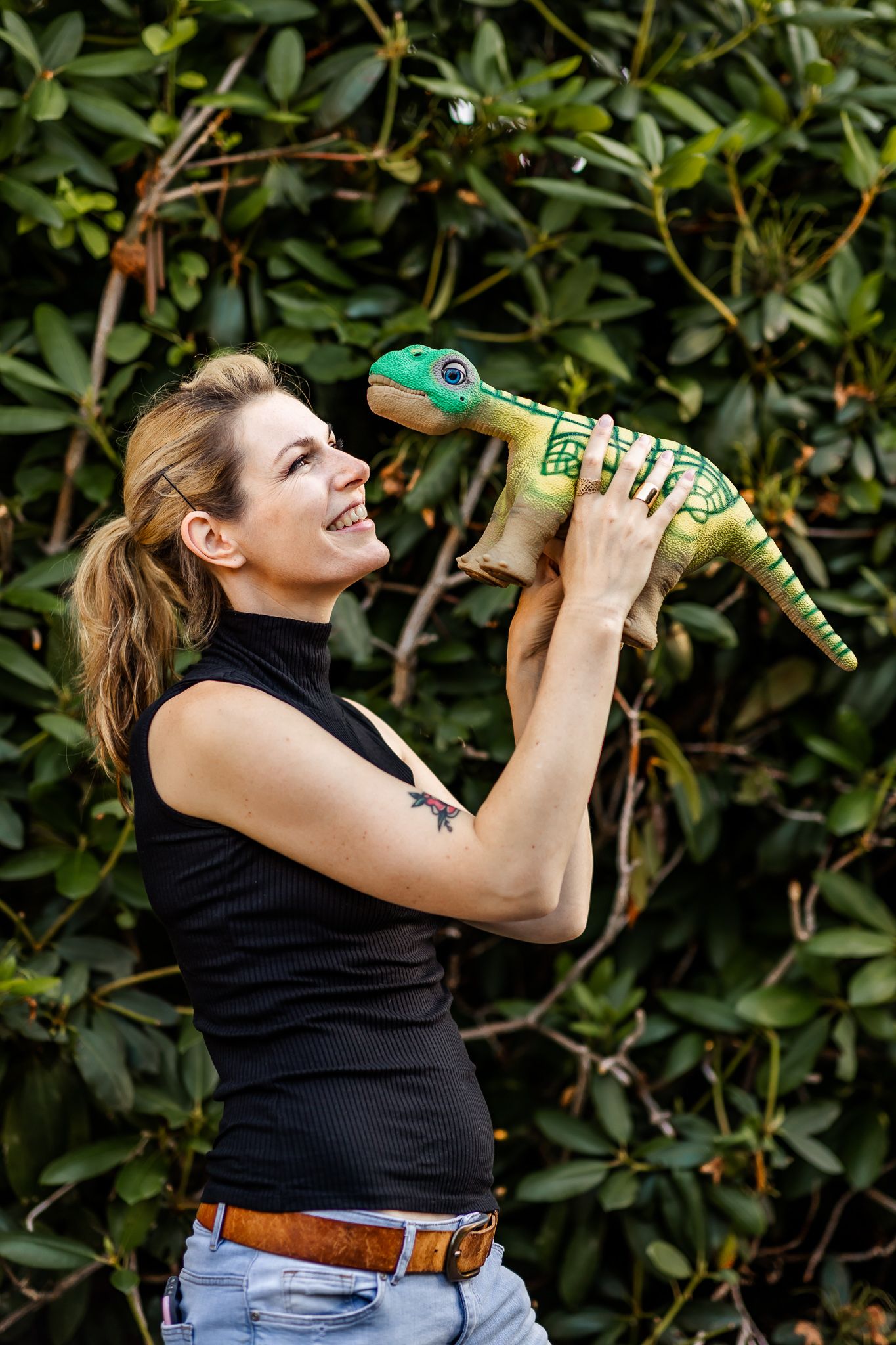 Researcher Kate Darling holds pleo robot up and smiles at it