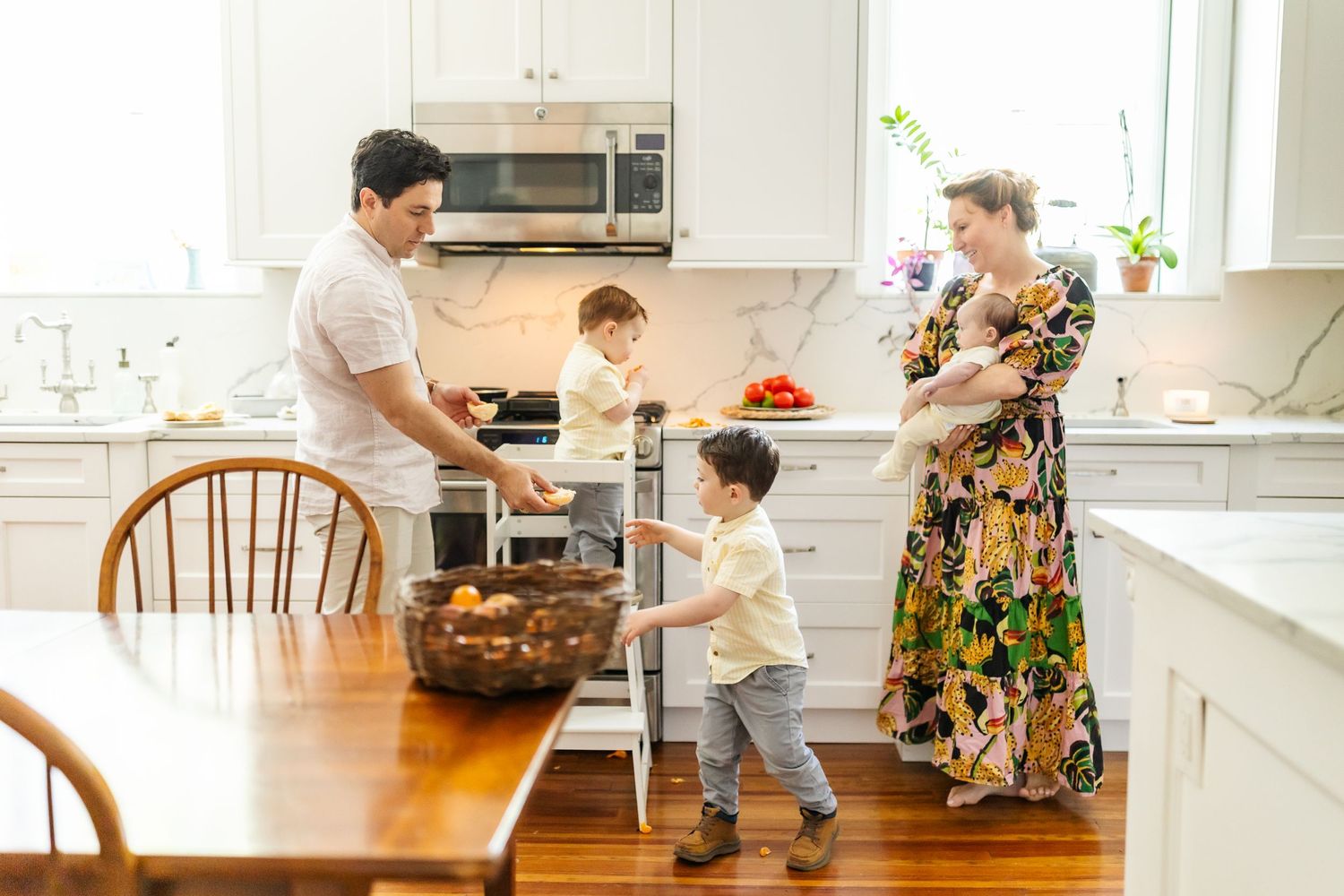 Candid family moments captured in bright white modern kitchen setting.
