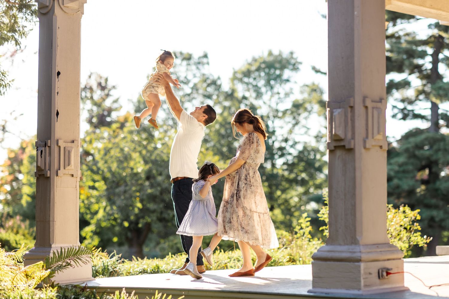 Outdoor portrait session at golden hour under white pillars with beautiful autumn light.