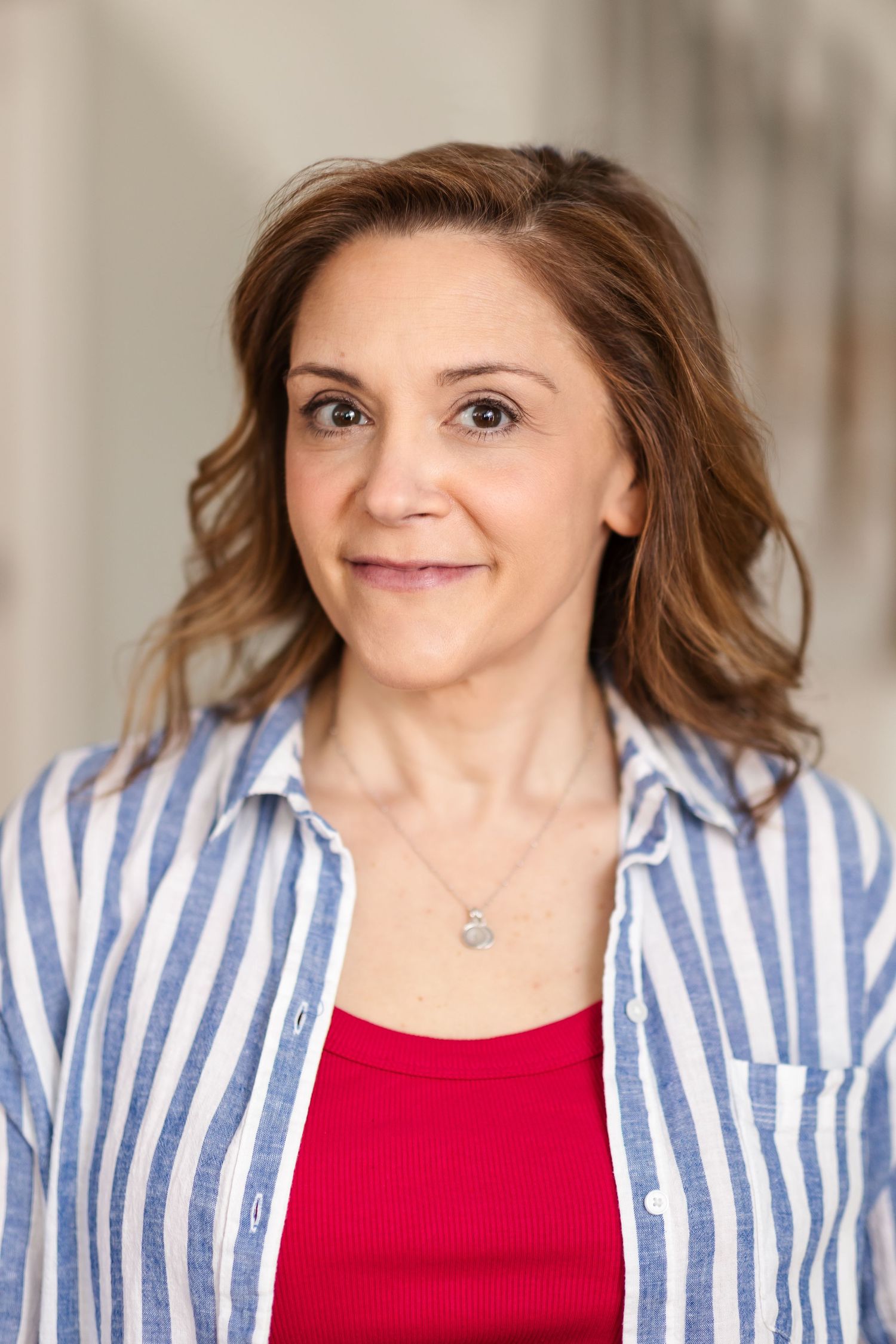 Woman in striped blazer and red top poses in a series of similar headshots against a light background.