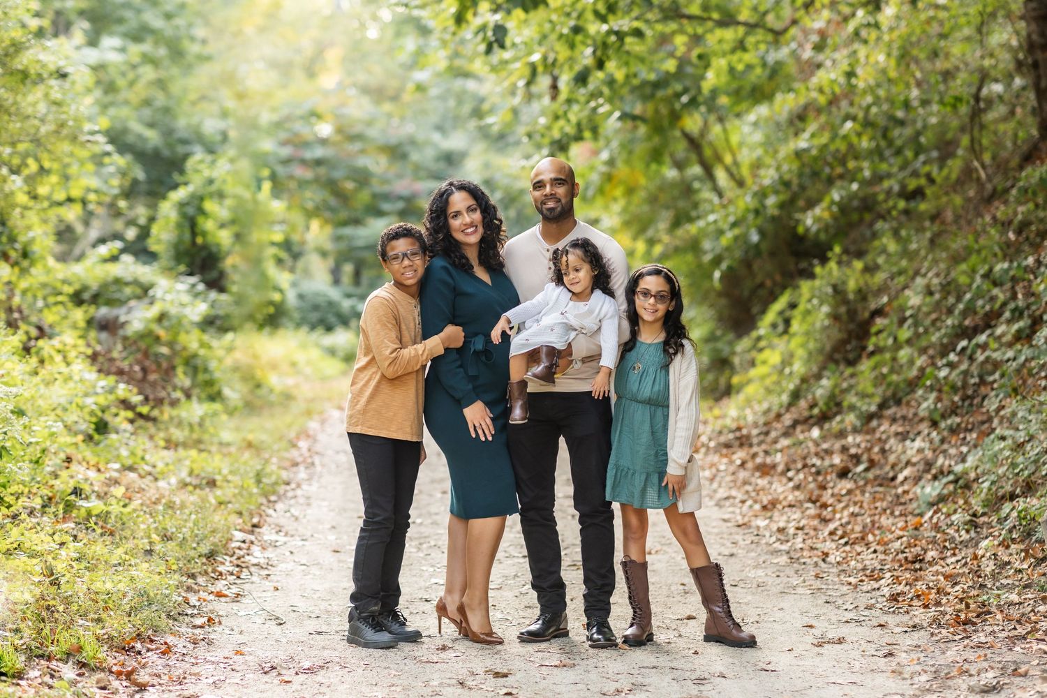 A group poses together on a scenic forest path during an outdoor photo session.