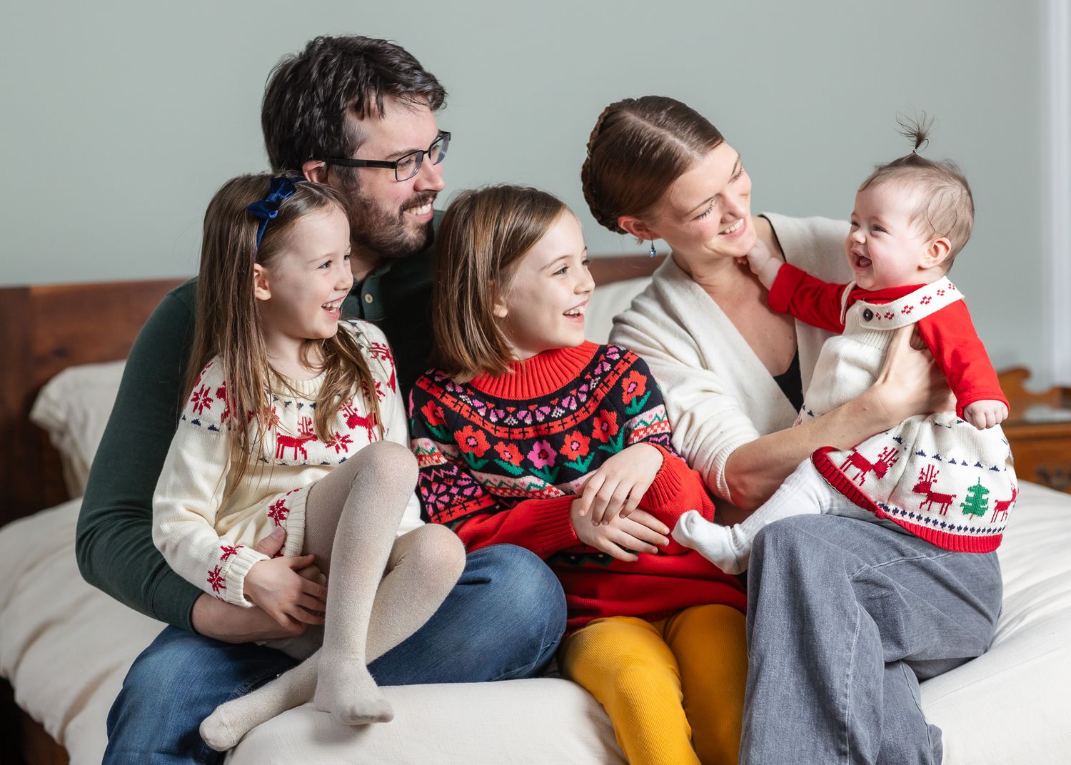 A series of candid family photos showing tender moments between parents and a baby in holiday attire.