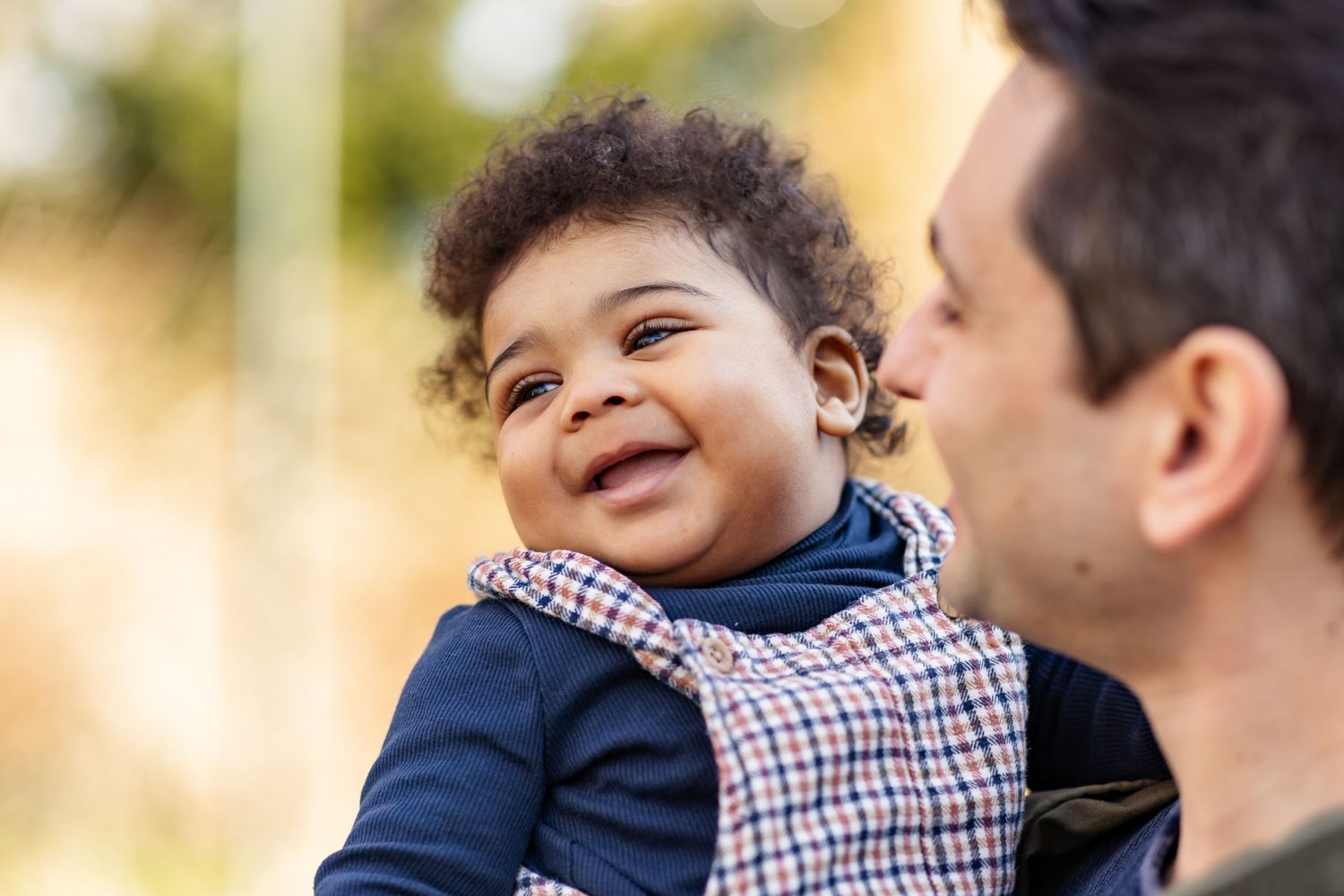 Joyful outdoor family portrait session with natural autumn lighting.