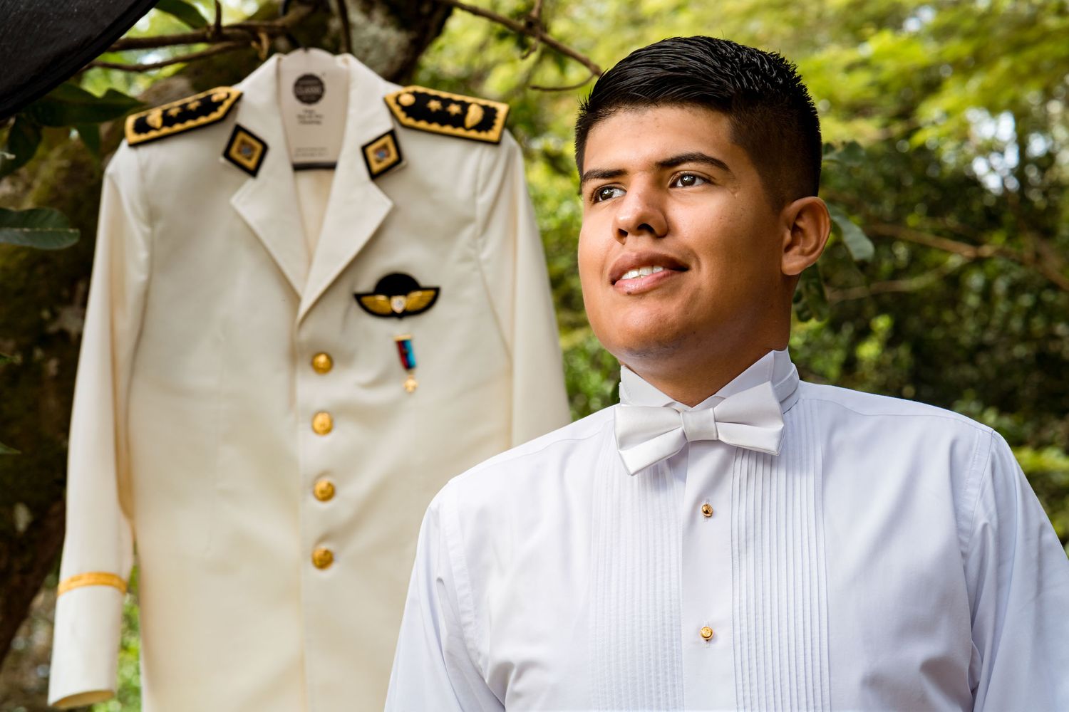 Novio posa con orgullo junto a su uniforme de gala militar antes de la ceremonia