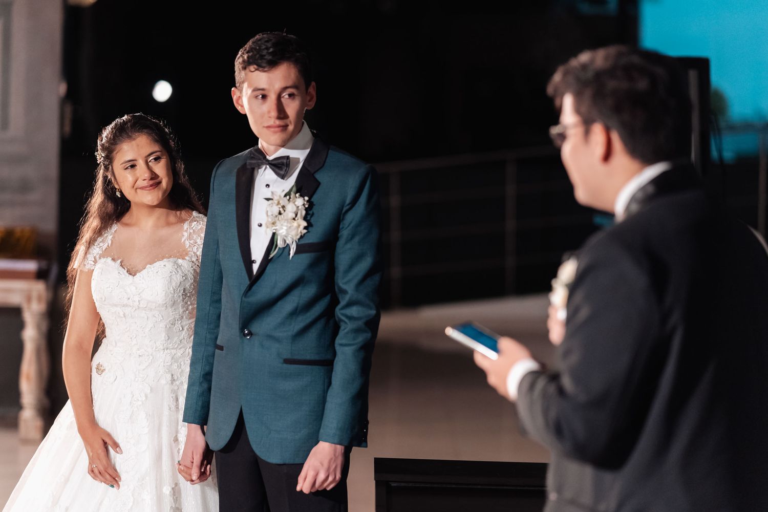 Novios escuchando atentamente al oficiante durante ceremonia de boda