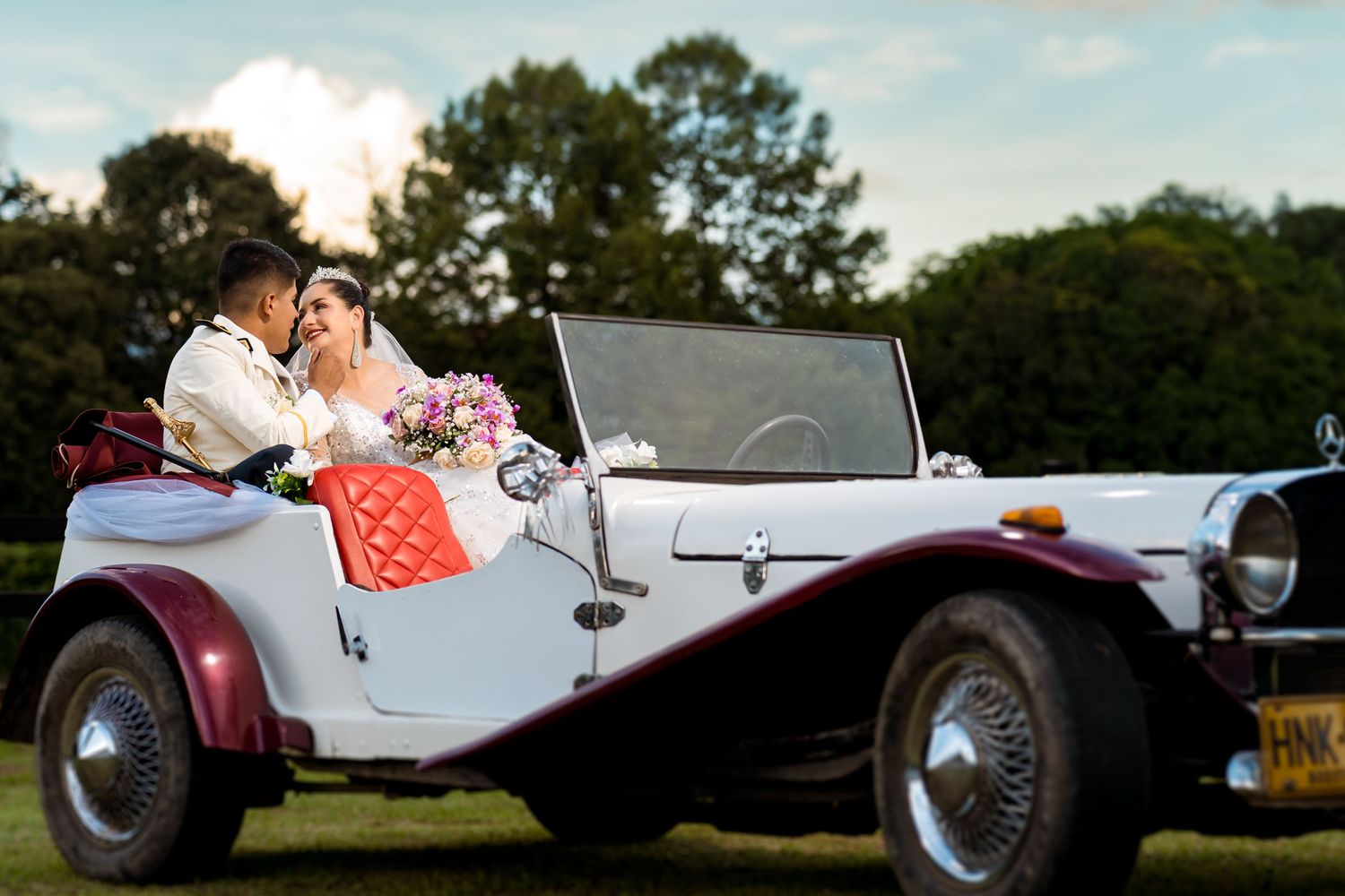 Los novios se alejan en un carro clásico convertible después de su boda