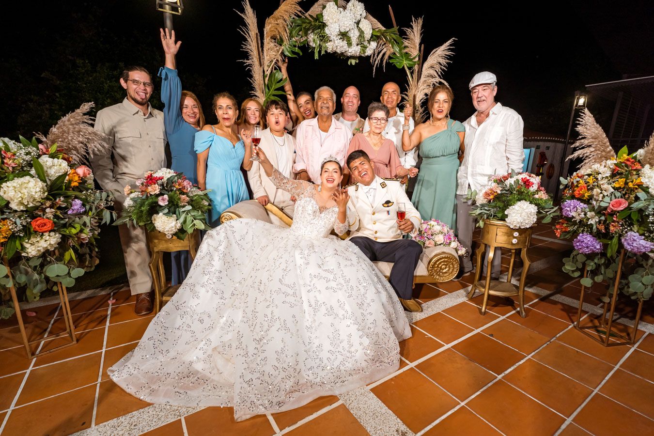 Amigos y familiares celebran con los recién casados en una animada foto grupal durante la fiesta.