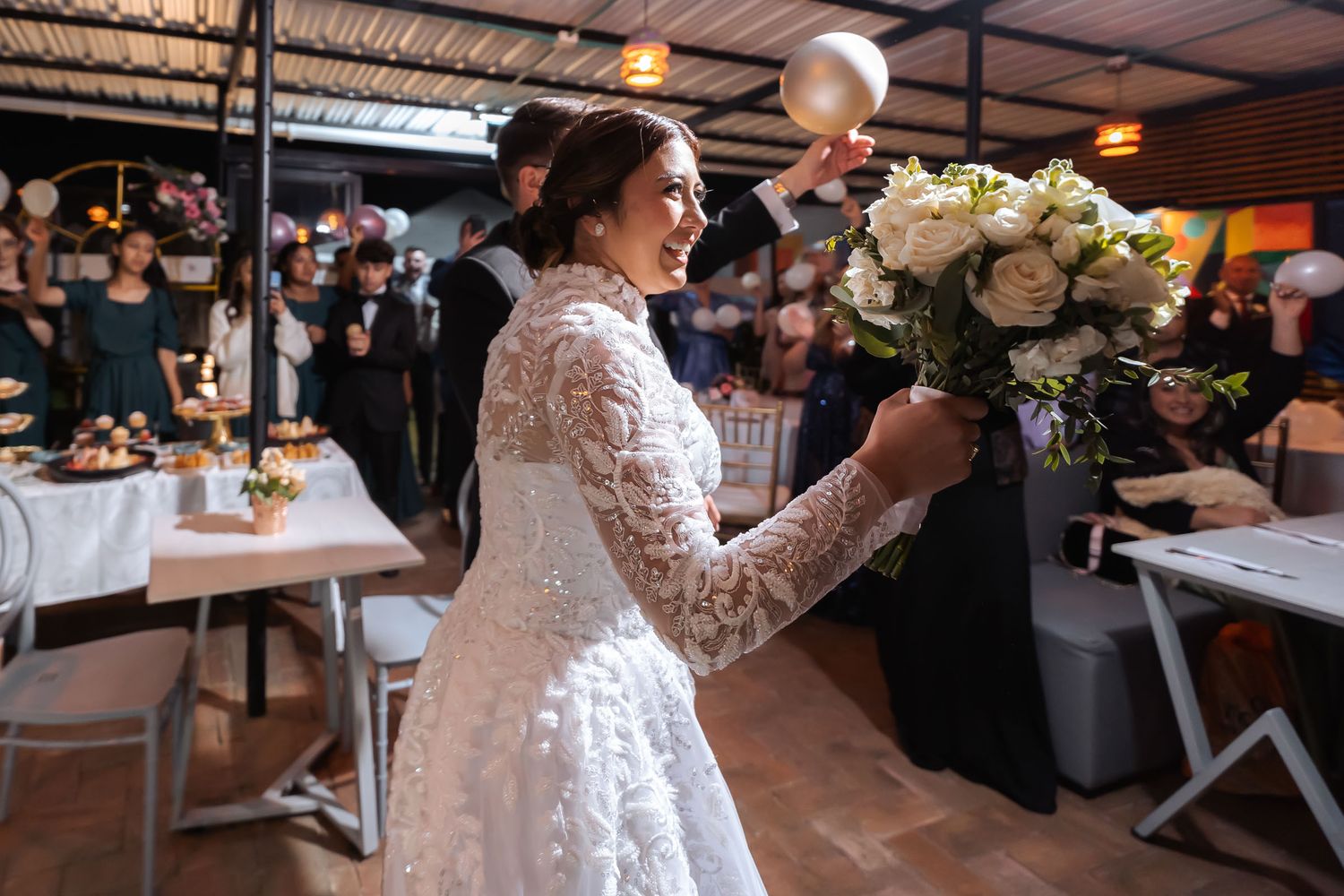 Momento del corte de tarta: Novia con ramo se dirige hacia el novio con cuchillo en mano en la recepción de boda.