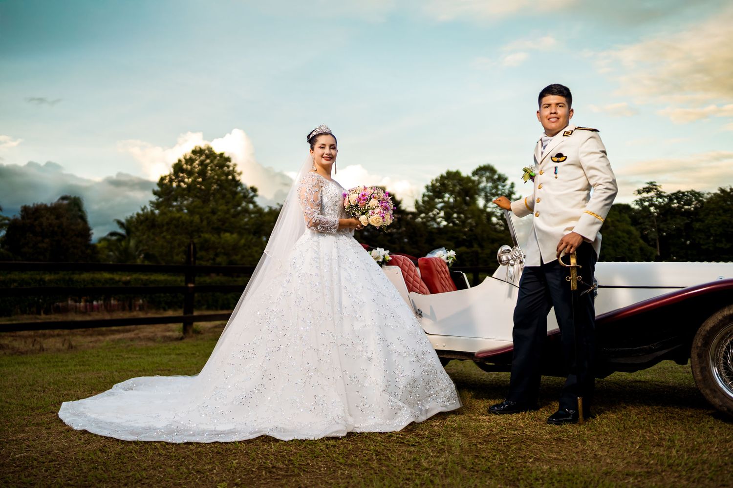 Sesión de fotos de boda al atardecer con un carro antiguo, mostrando a los novios en un paisaje de campo