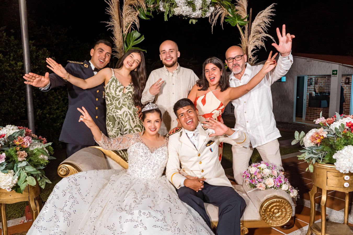 Novios y amigos celebran con entusiasmo levantando las manos en la fiesta de bodas en Villavicencio