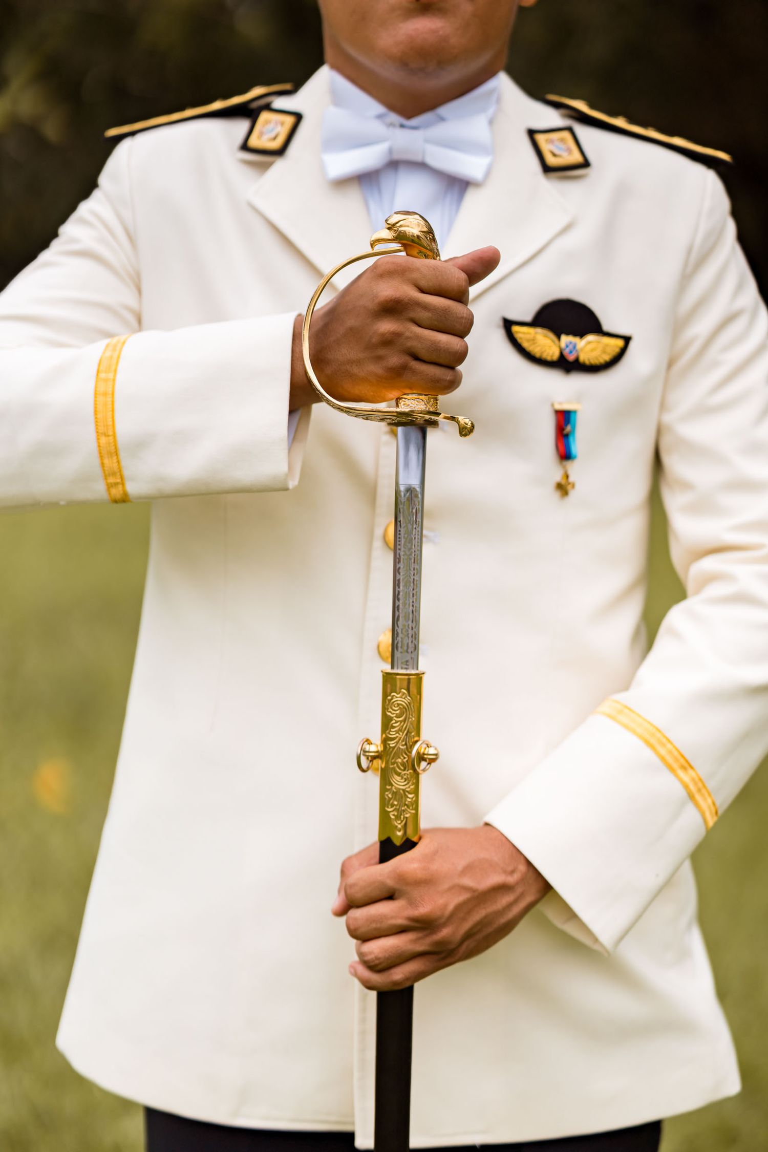 Detalle del novio sosteniendo su sable de gala militar mientras se prepara para la ceremonia