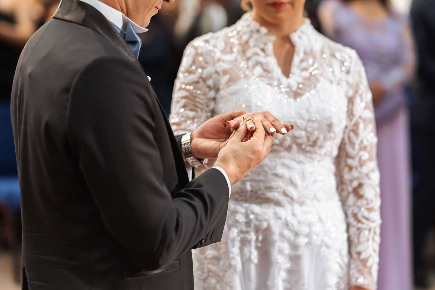 Intercambio de anillos en blanco y negro: Novio coloca anillo en el dedo de la novia durante ceremonia de boda.