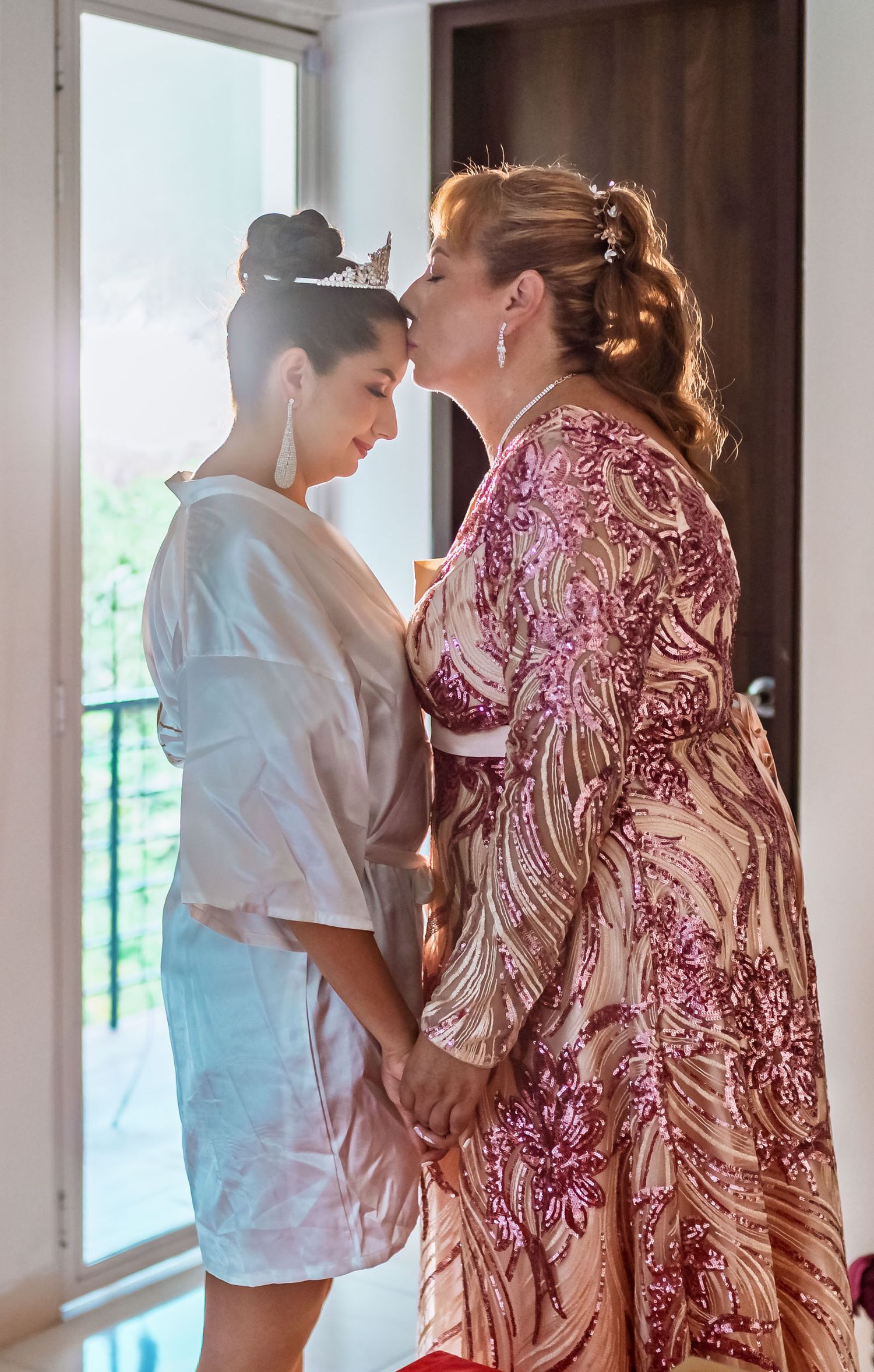 La novia comparte un emotivo abrazo con su madre en el balcón antes de la boda