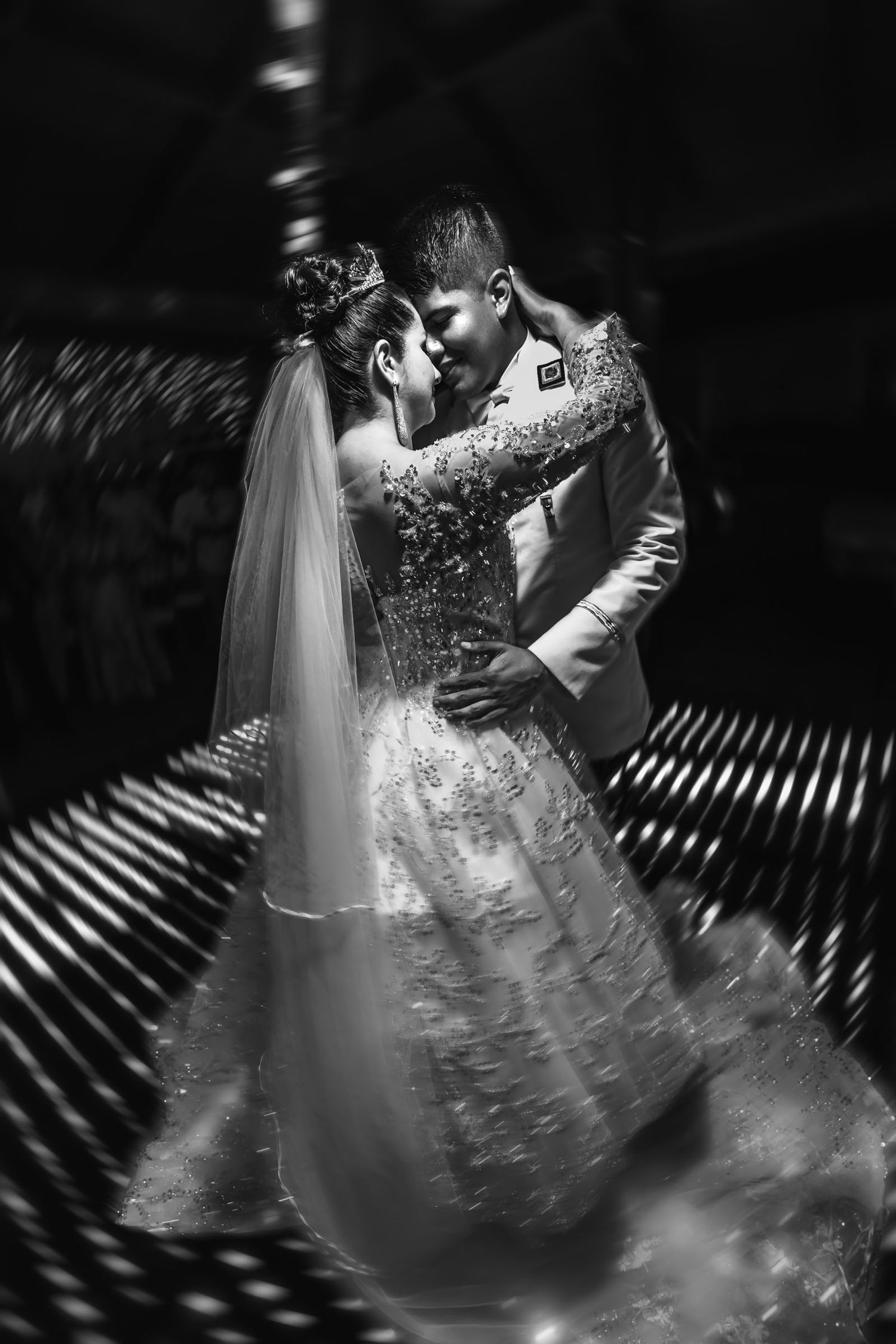 Foto artística en blanco y negro de los novios bailando un tema lento en su boda