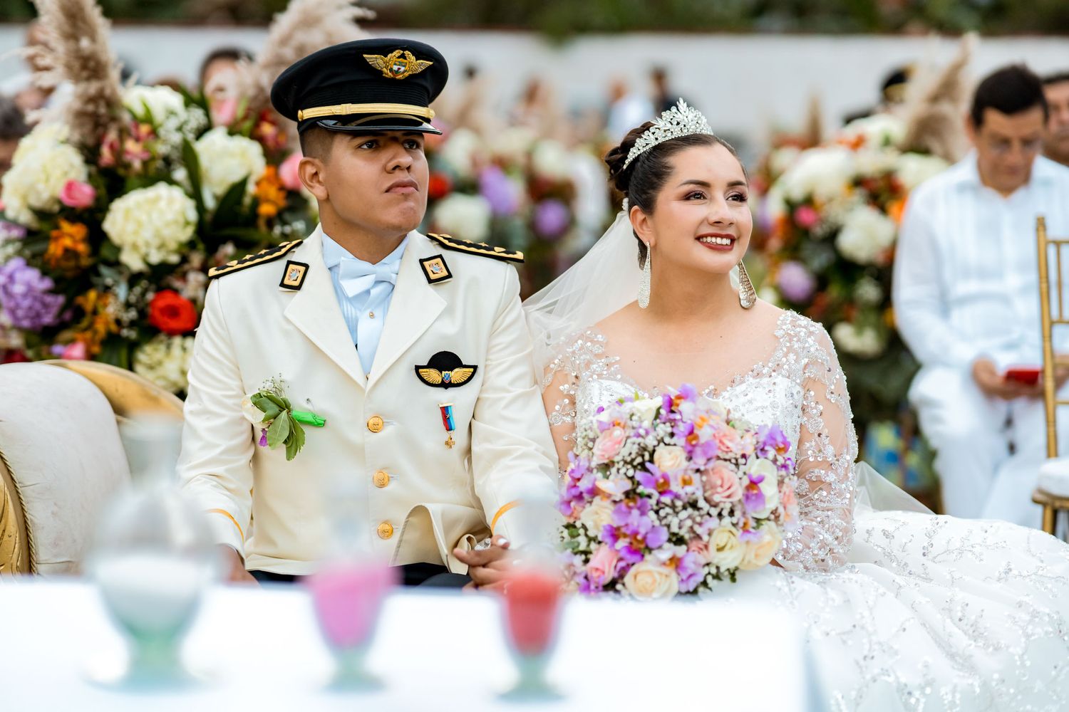 Los novios Leidy y Cris tomados de la mano frente al altar durante su ceremonia de boda