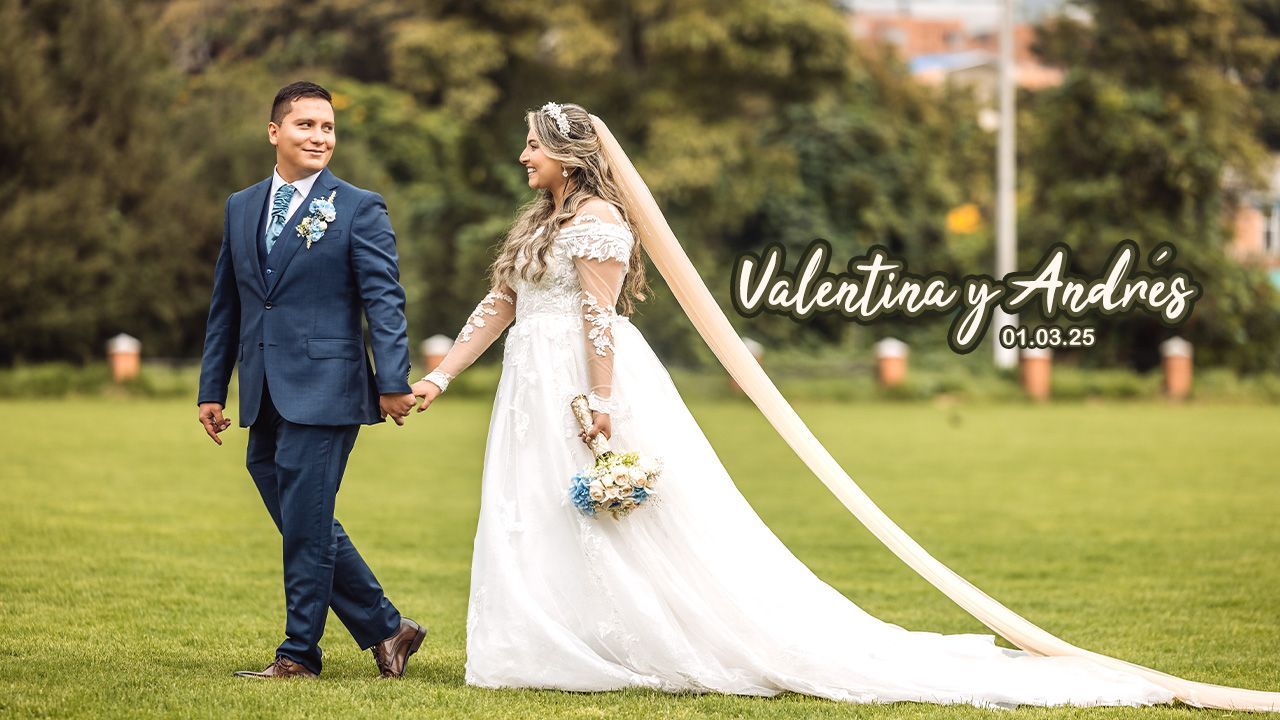 Novios Valentina y Andres caminan sonrientes tomados de la mano en jardín con césped. Vestido de novia con cola; novio con traje azul