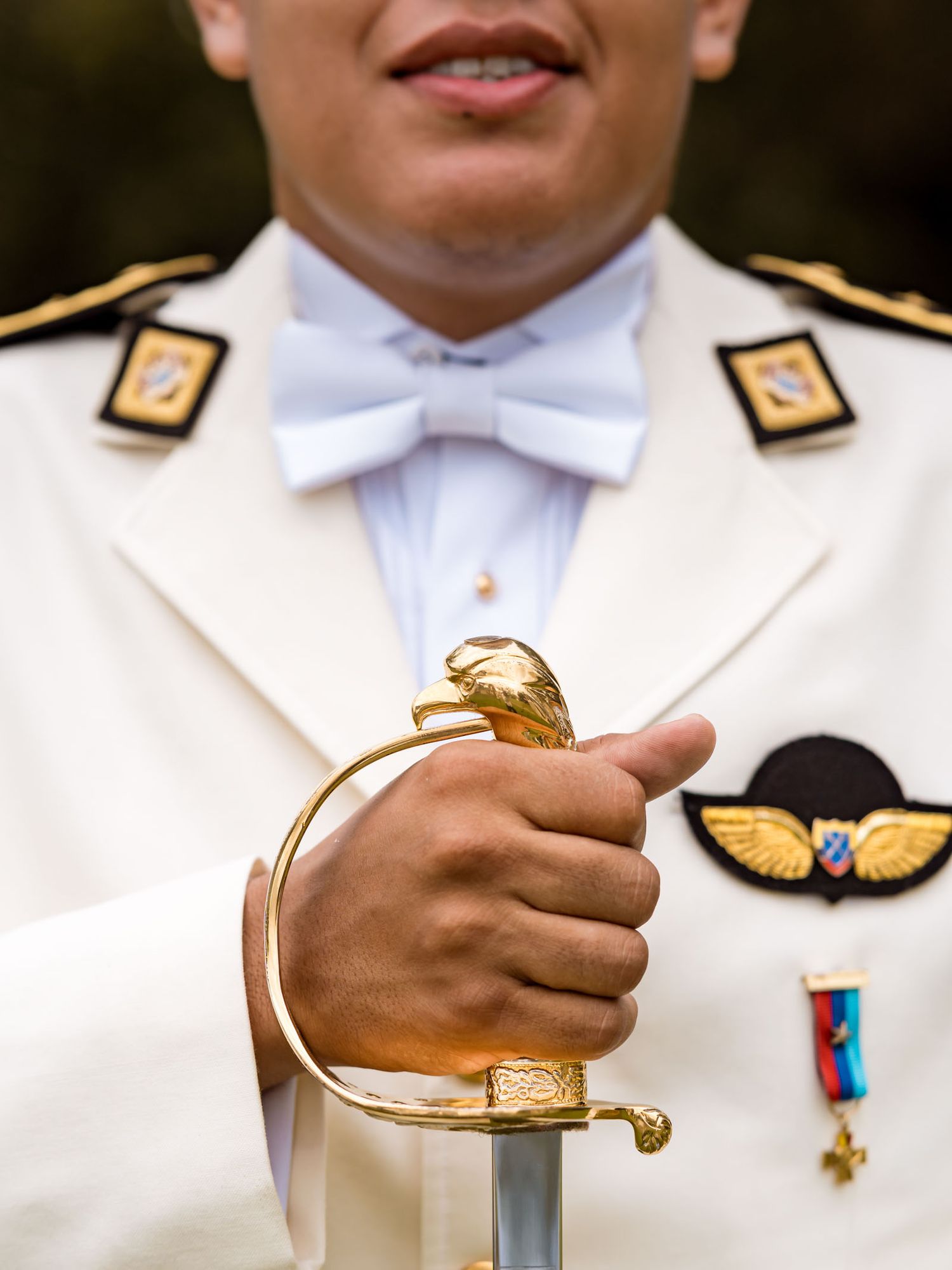 Primer plano del uniforme de gala del novio y la empuñadura de su sable