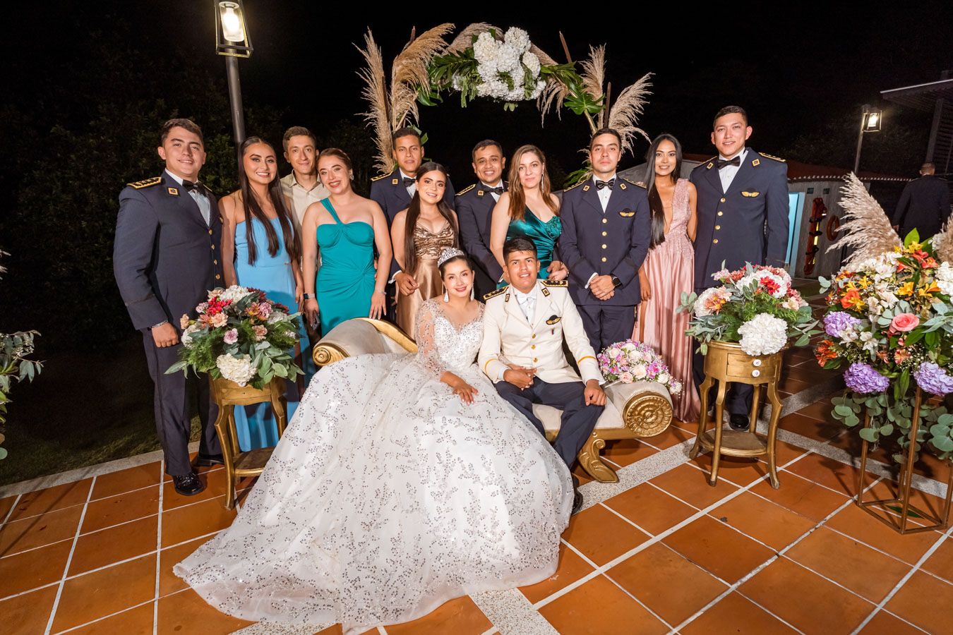 Retrato formal del grupo de boda con los novios Leidy y Cris sentados al centro