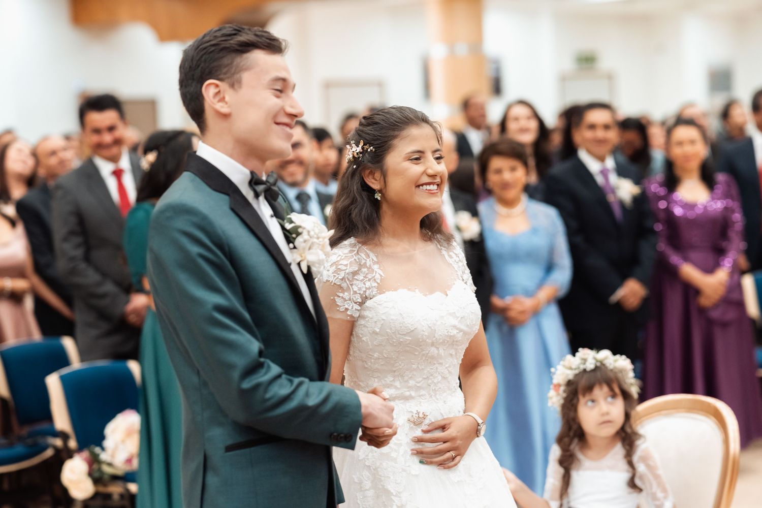 Novios sonrientes junto a pajecita durante celebración de boda.