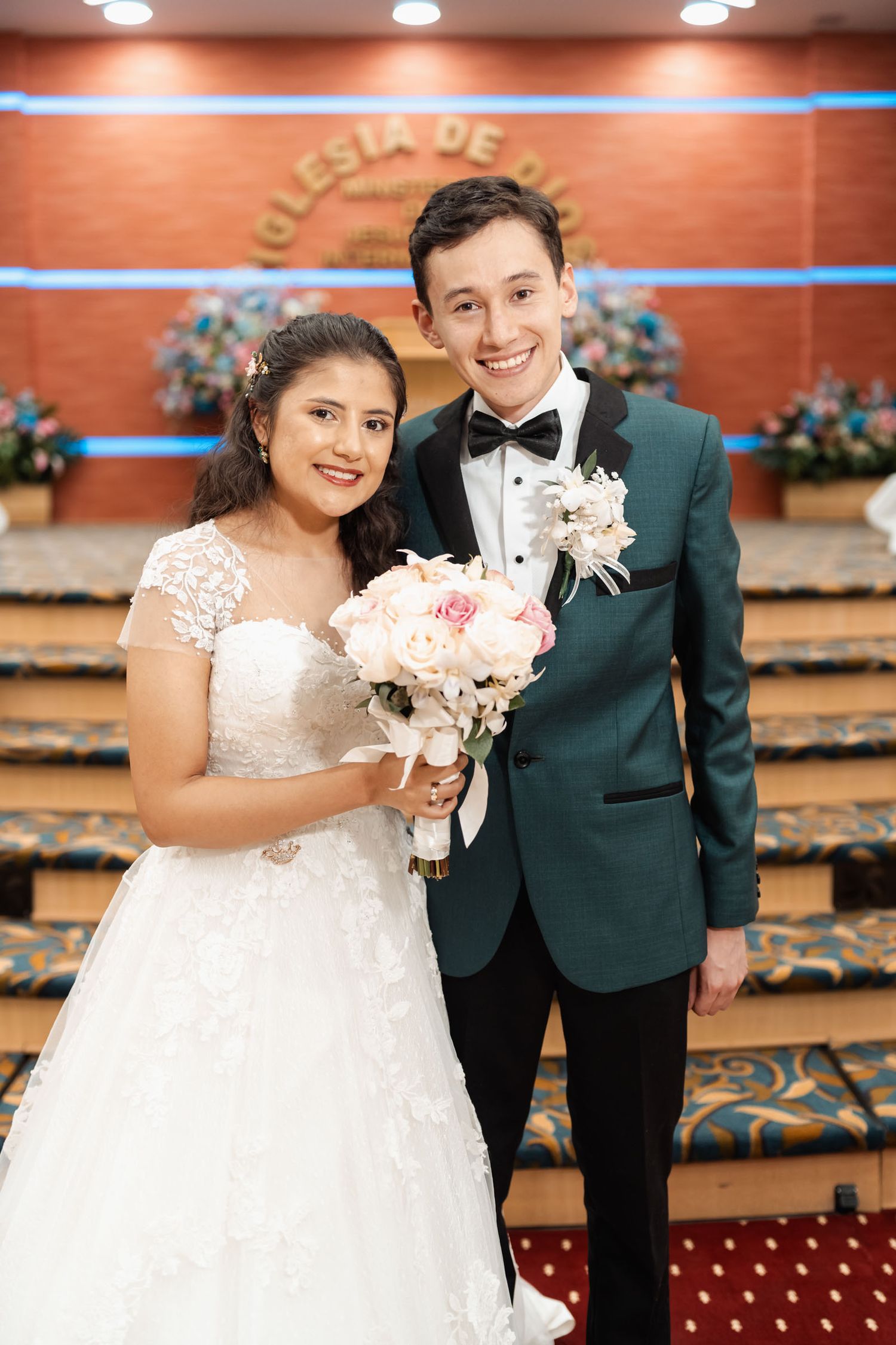 Novios sonrientes caminando por pasillo en salida de ceremonia entre aplausos