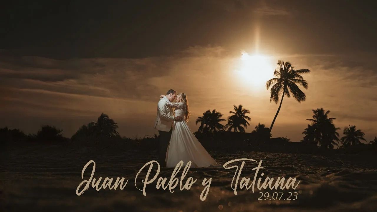 Pareja de novios se abraza en playa de Miami al atardecer, siluetas contra el sol y palmeras. Foto romántica de boda.