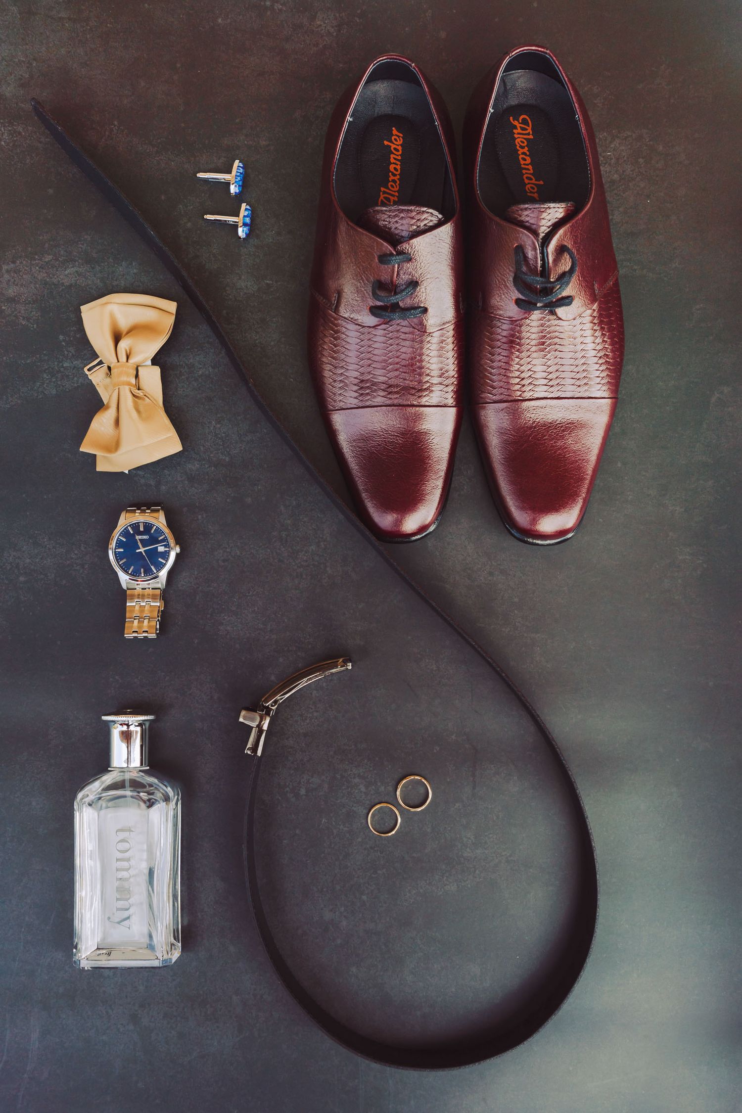 Accesorios del novio incluyendo zapatos de cuero y reloj, en un flat lay.