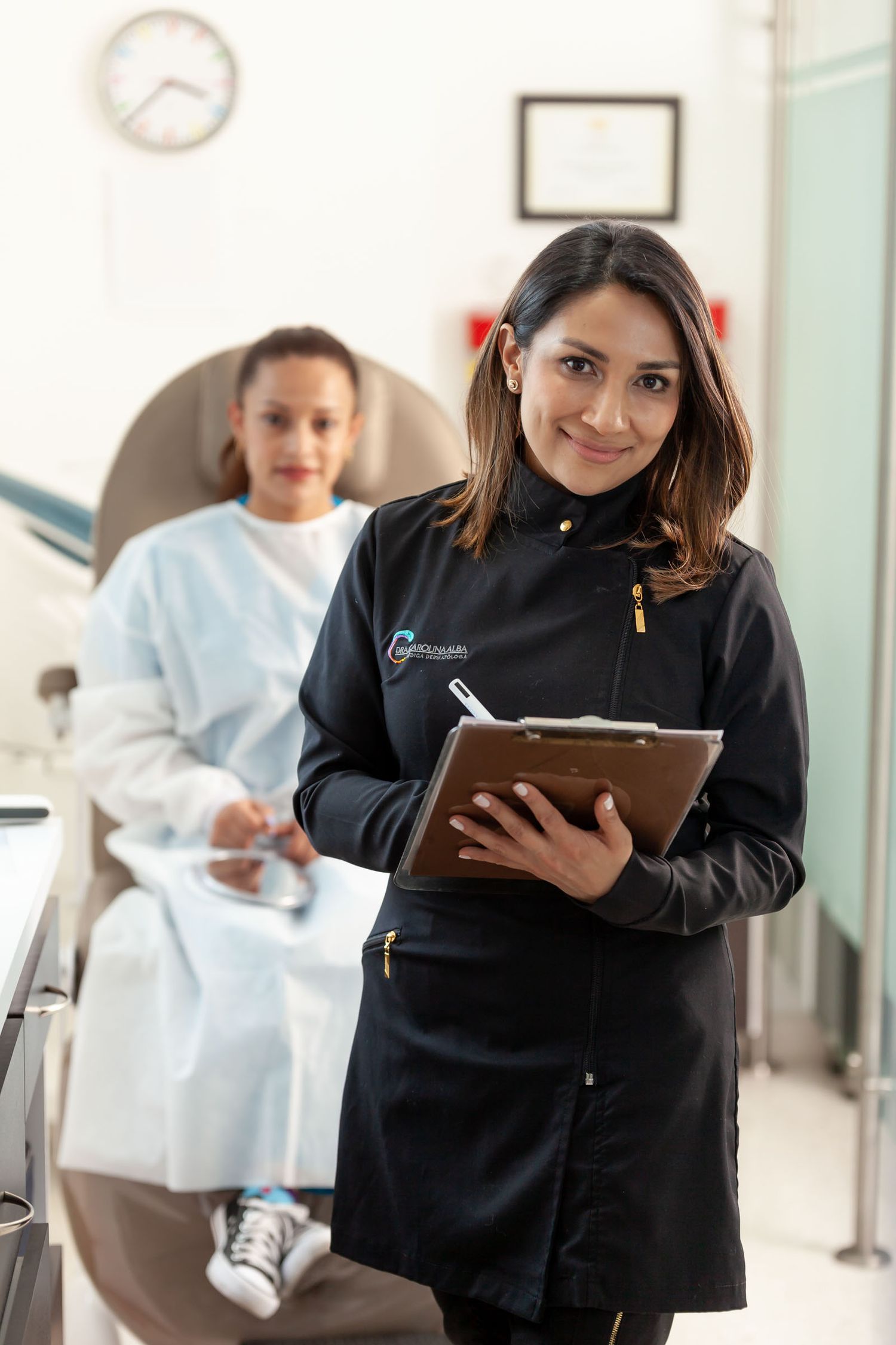 Primer plano en un retrato corporativo de una mujer dermatóloga junto a su paciente en el consultorio.