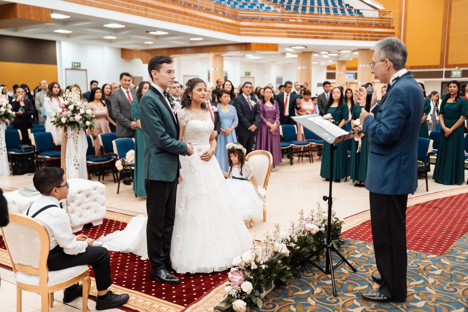 Novio dando discurso con micrófono a novia sonriente en recepción de boda