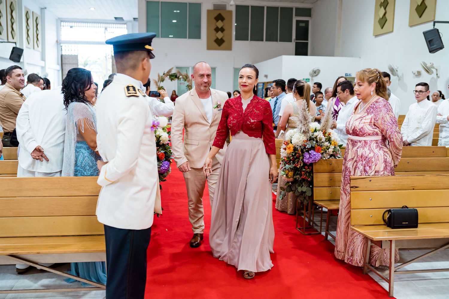 Testigos de los novios caminan por el pasillo de la iglesia al inicio de la ceremonia de boda en Villavicencio