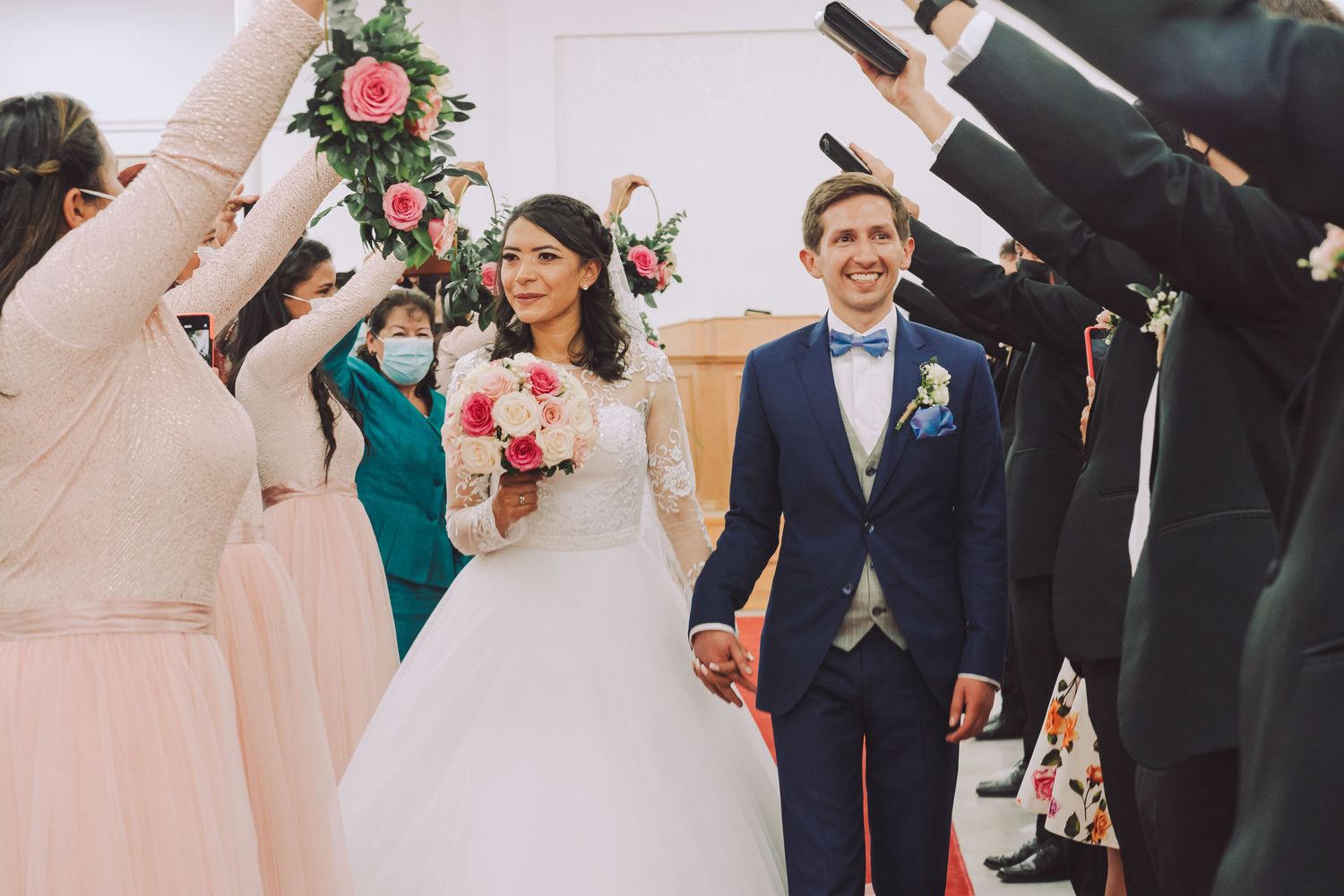 Novios caminando por el pasillo de la iglesia durante la salida de su ceremonia.