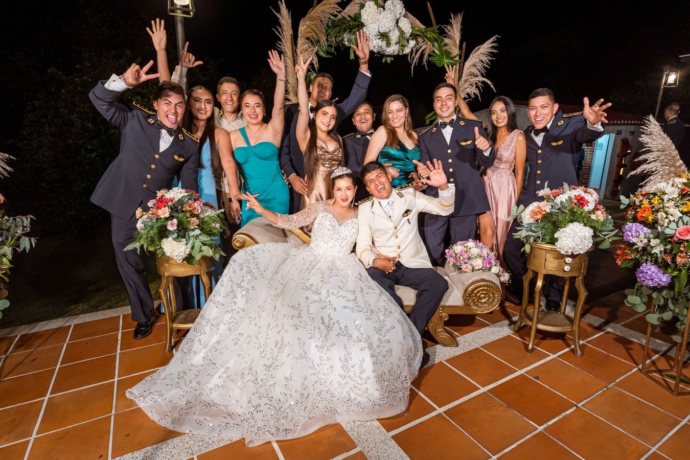Foto panorámica del grupo de invitados posando alegremente con los novios en la fiesta de bodas