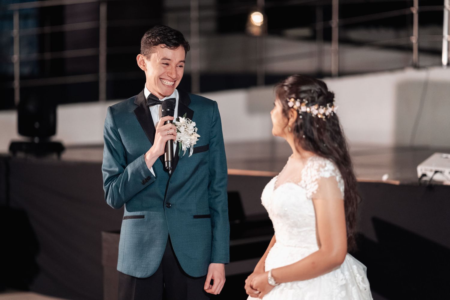 Novio con micrófono dedica palabras emotivas a la novia sonriente en recepción