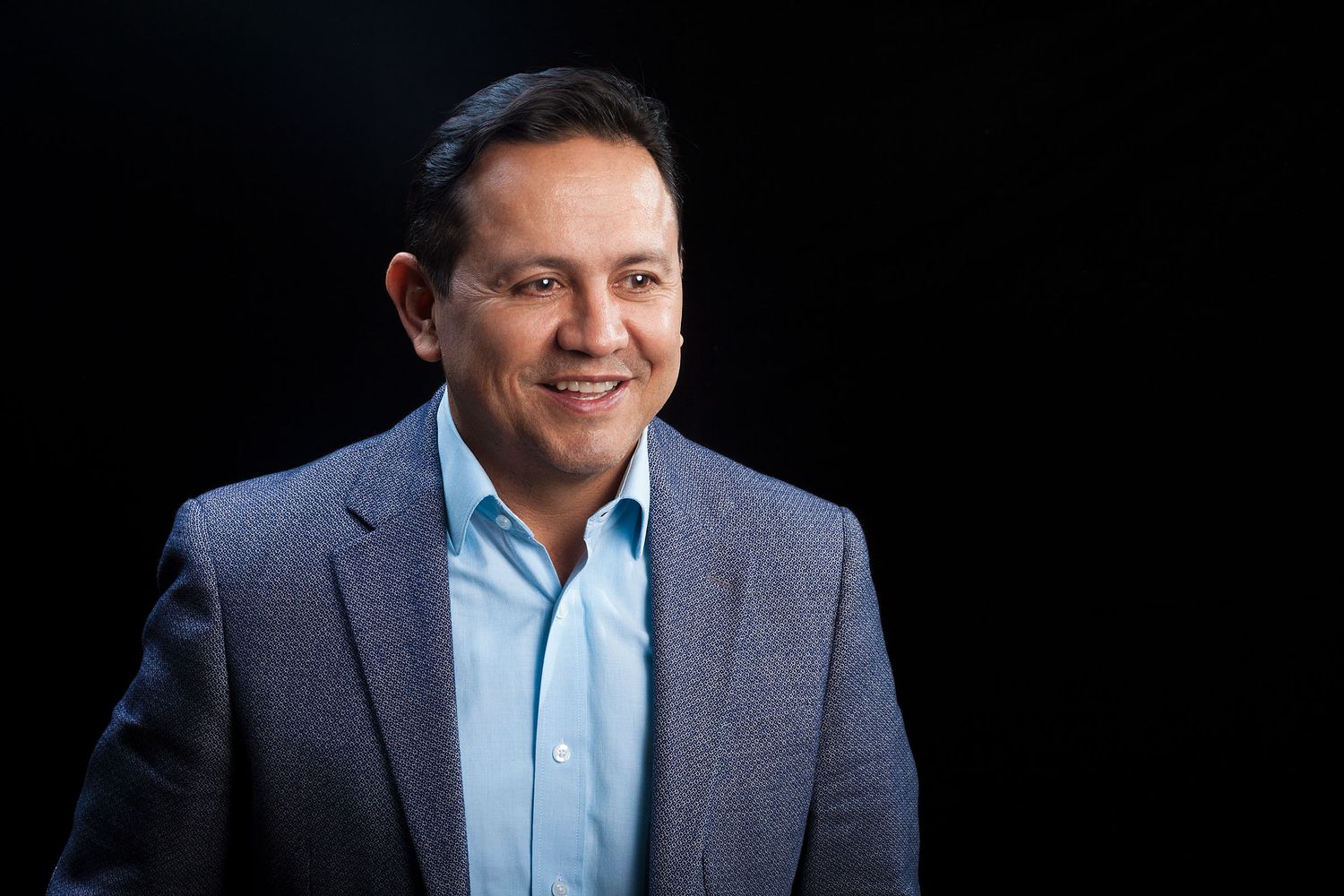 Retrato corporativo de un hombre sobre un fondo negro