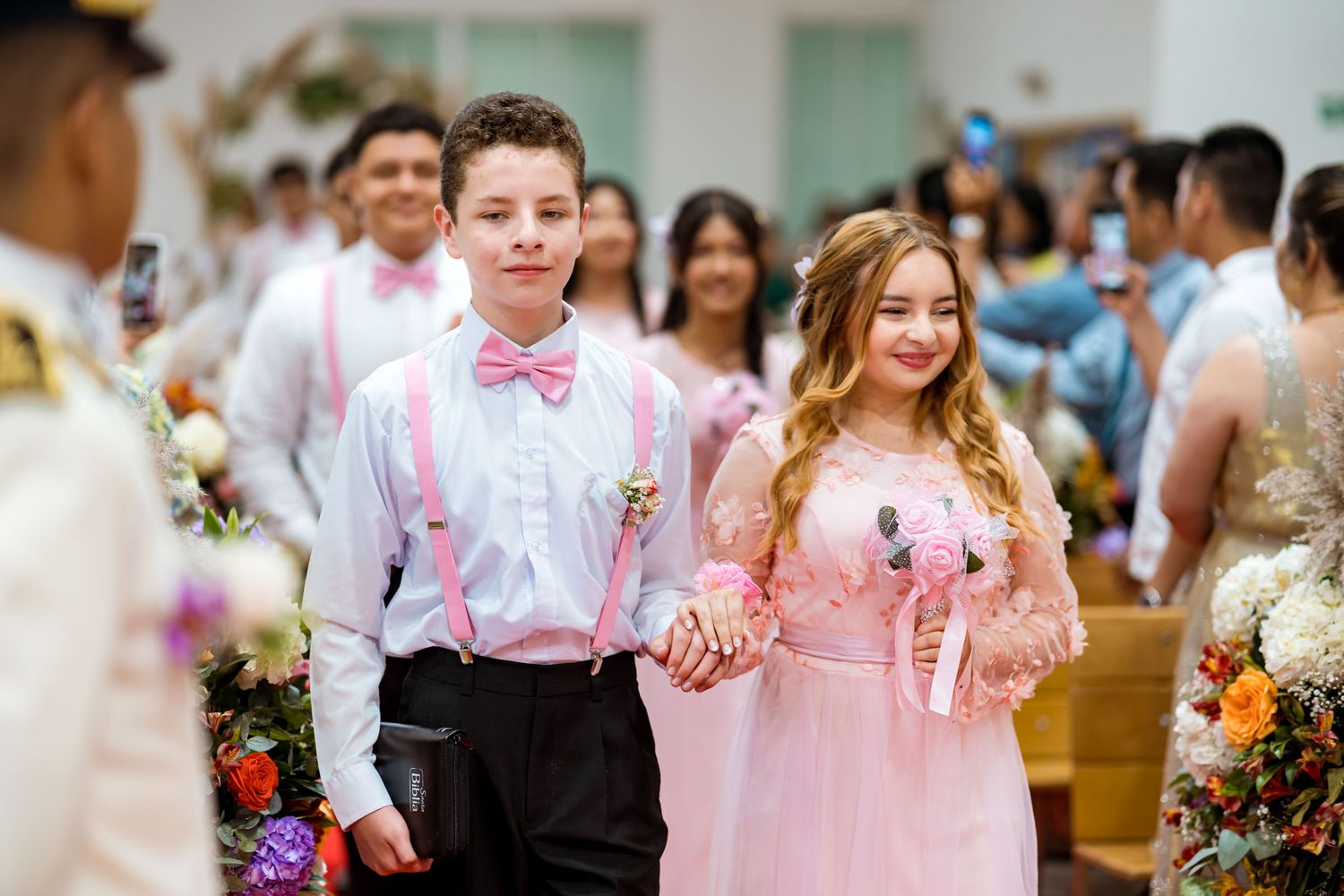 Pareja de la corte, un niño y una niña, caminan por el pasillo de la iglesia durante la ceremonia