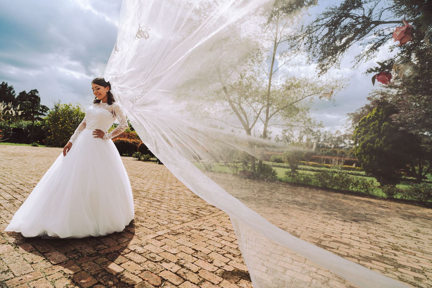Novia con su velo largo ondeando al viento en una hacienda de Cajicá.