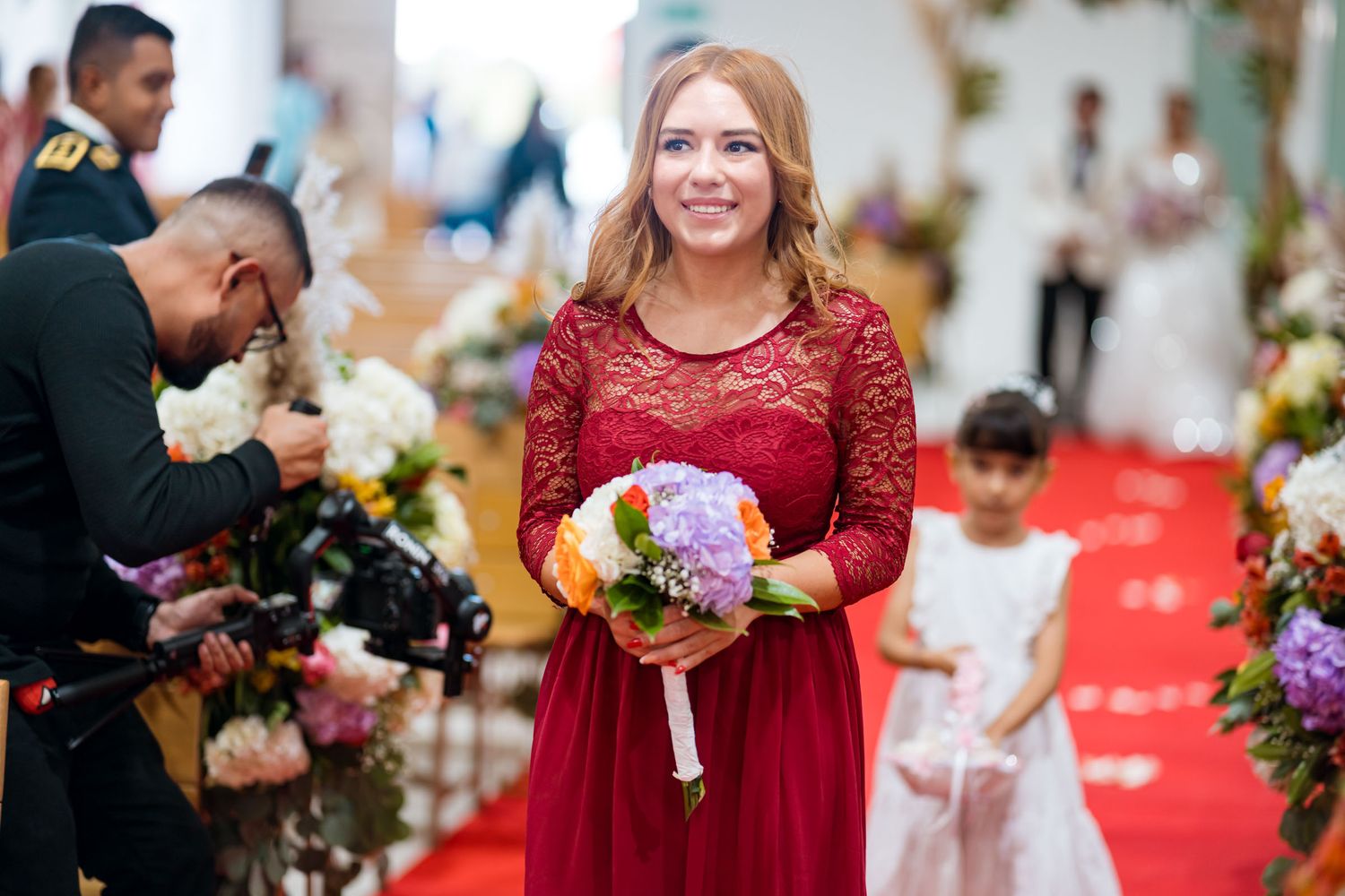 Dama de honor camina por el pasillo durante la entrada a la ceremonia de boda