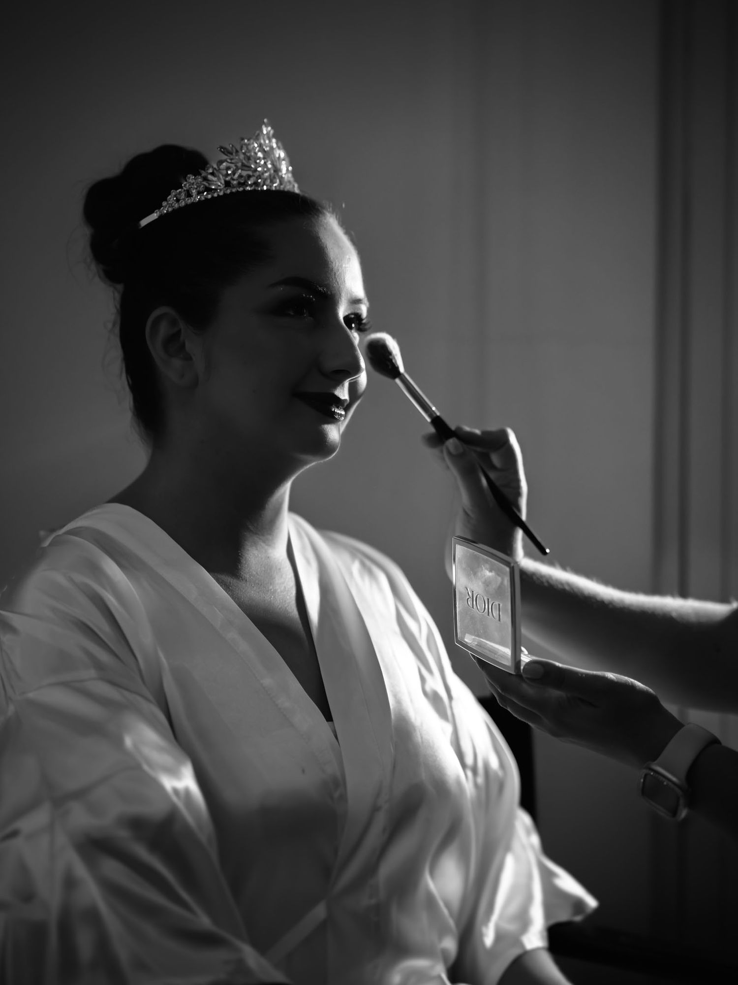 La novia recibe los últimos toques de maquillaje, fotografía artística en blanco y negro