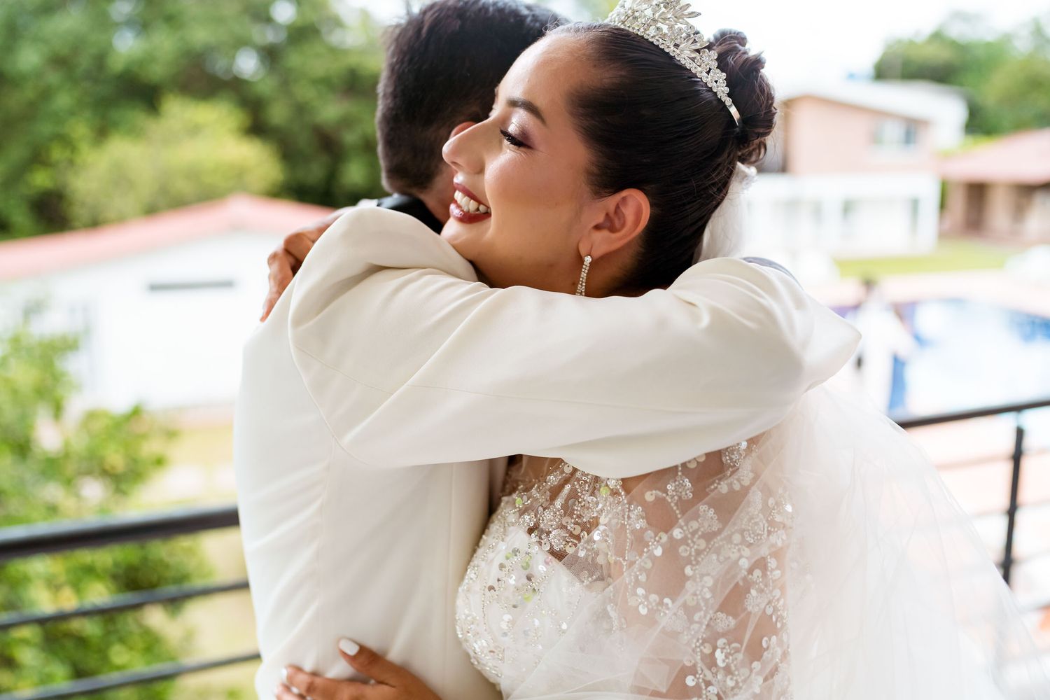 La novia abraza a su padre con emoción en el balcón antes de la ceremonia de boda.
